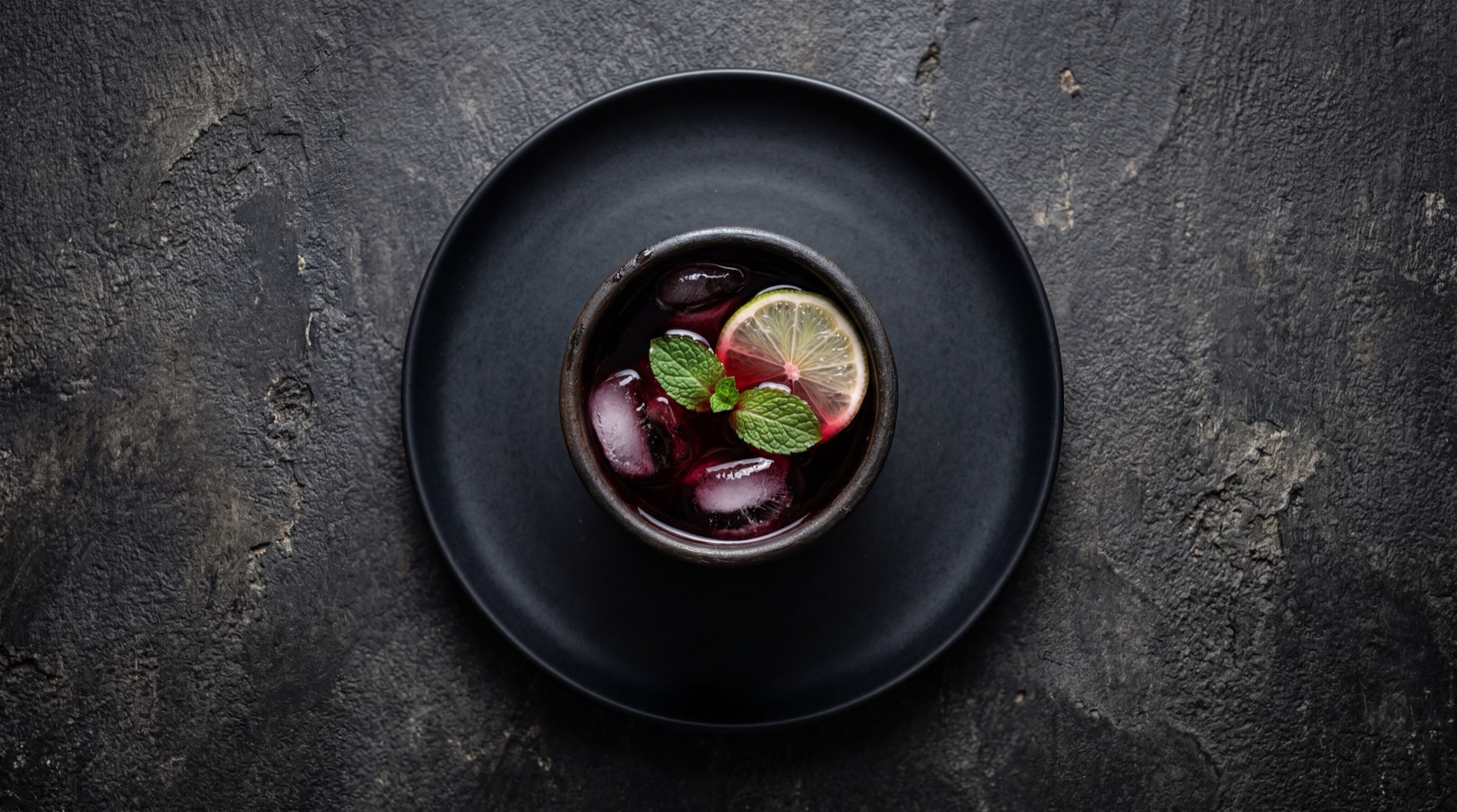 Agua de jamaica mexicana version saludable sin azucar en vaso de vidrio con rodaja de limon verde y hielo