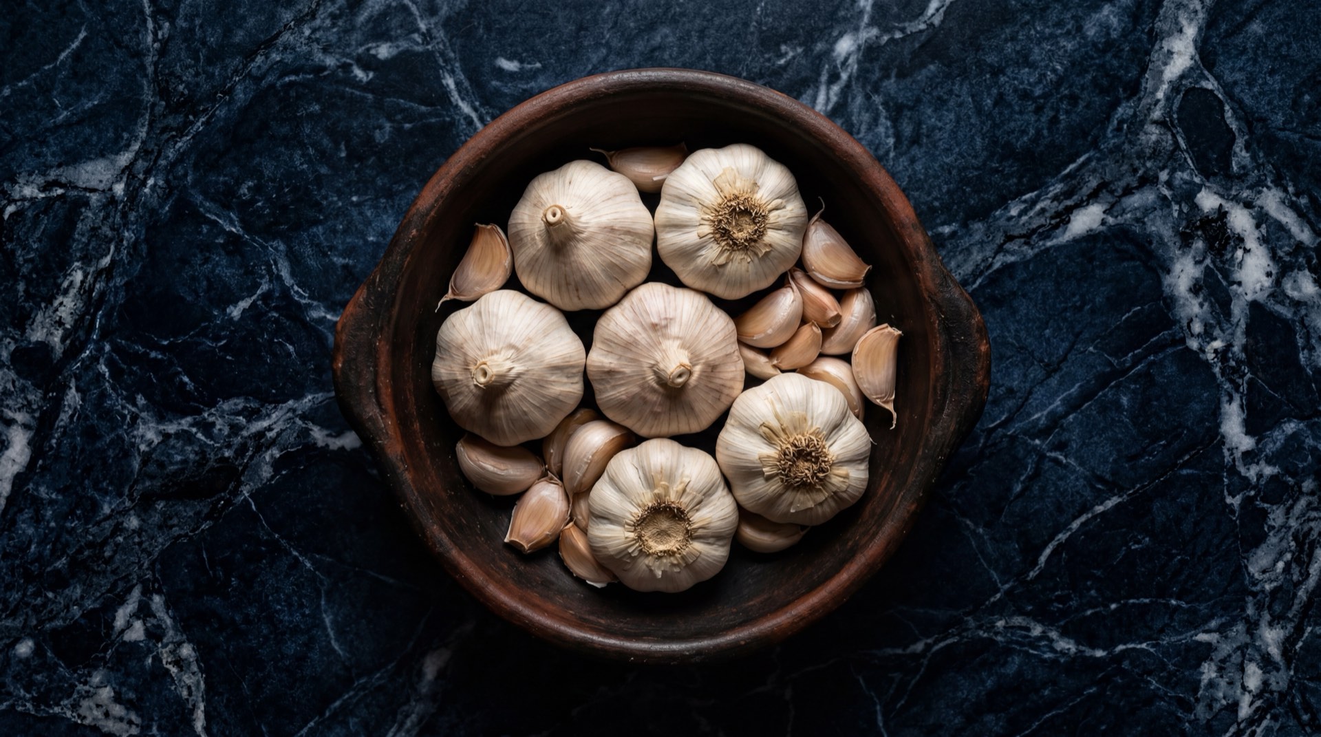 Cabezas de ajo fresco abiertas con dientes visibles, rica fuente de alicina y compuestos antibacterianos