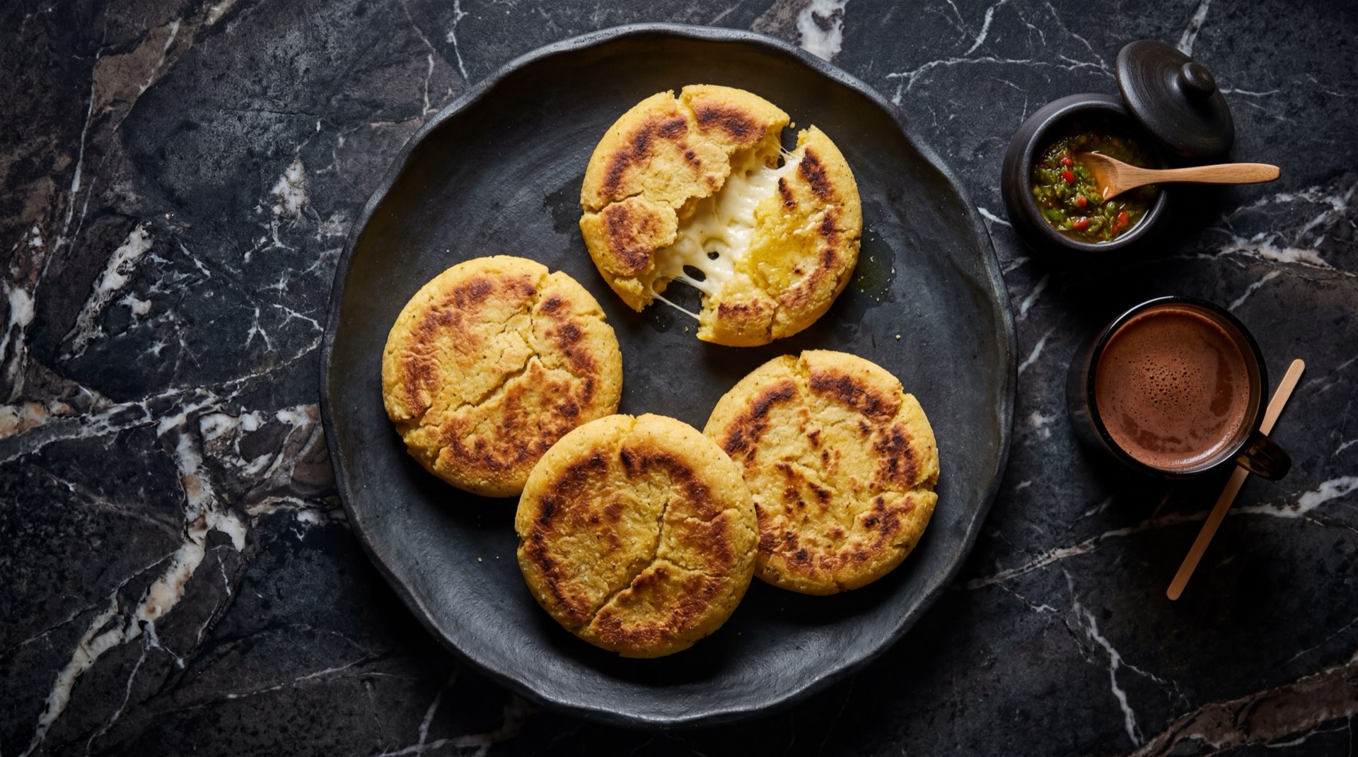 Arepa boyacense colombiano abierto en hoja de platano mostrando masa de maiz con pollo desmechado cerdo papa criolla zanahoria y arvejas verdes frescas