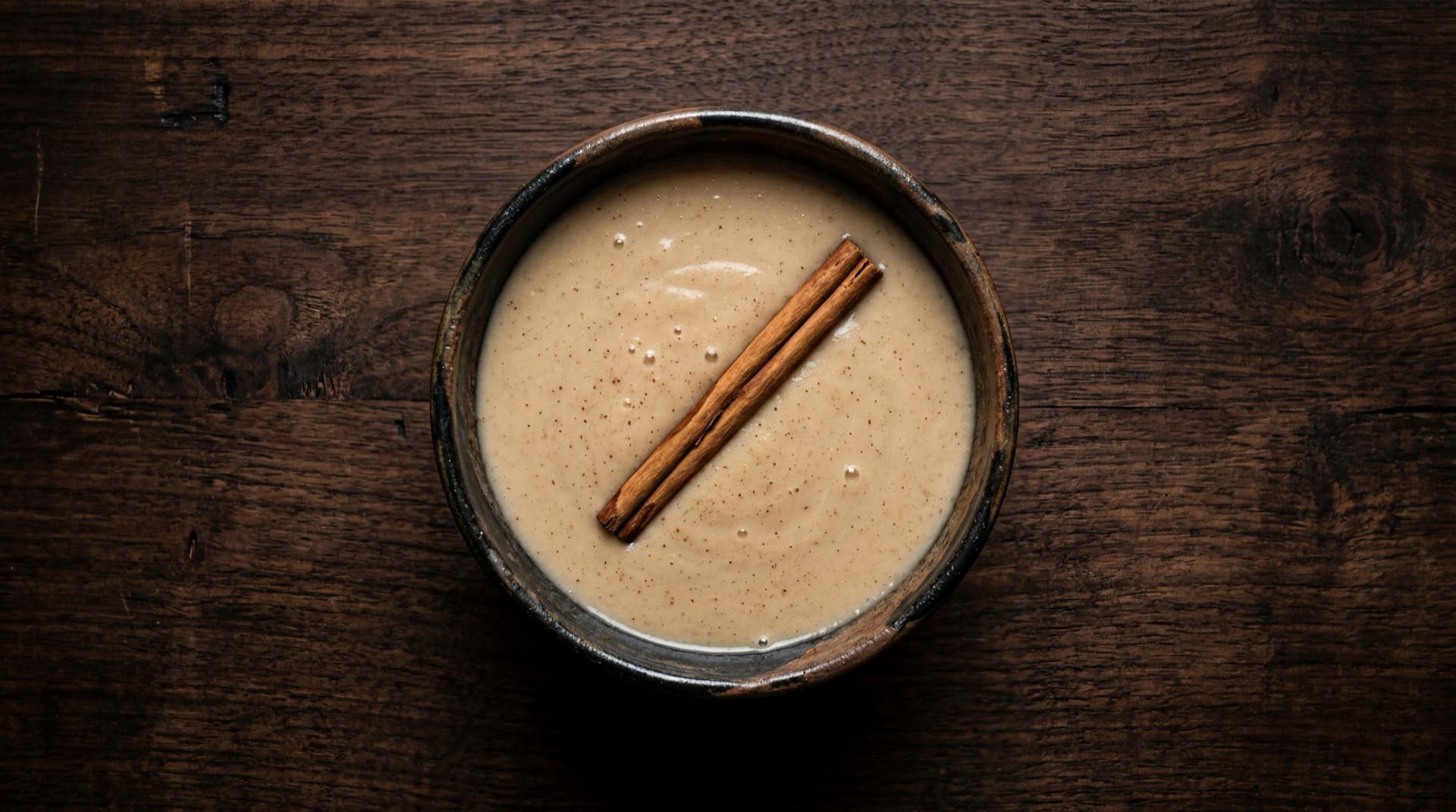 Atole mexicano tradicional servido en plato oscuro sobre mesa de marmol negro