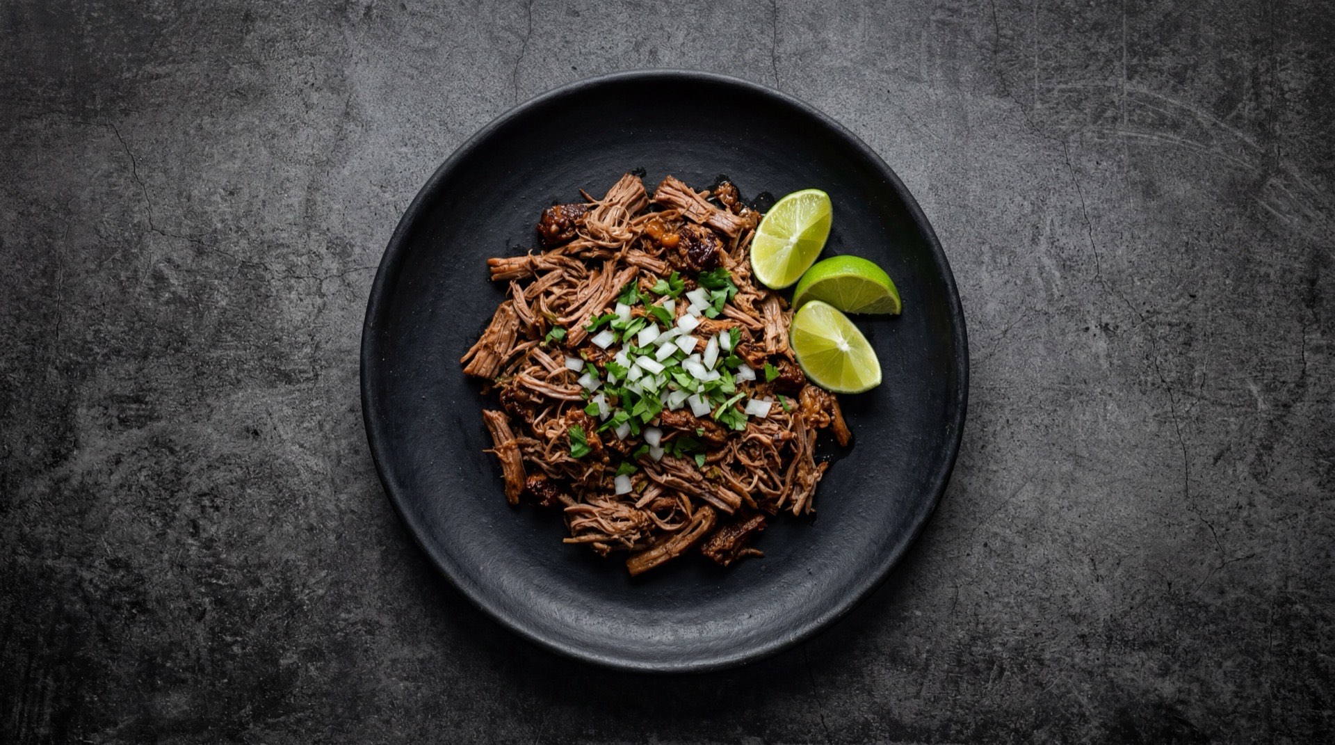 Barbacoa de borrego version saludable con corte magro desgrasado sobre hojas de lechuga con salsa verde de tomatillo y limon verde