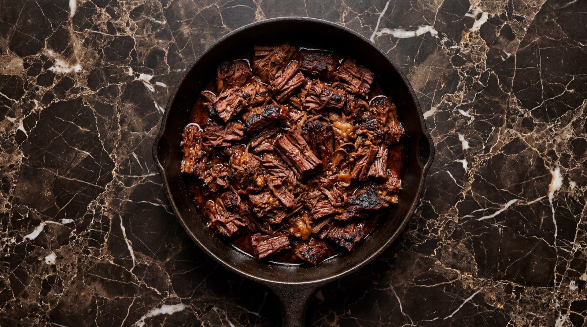 Barbacoa de Res mexicano tradicional servido en plato oscuro sobre mesa de marmol negro