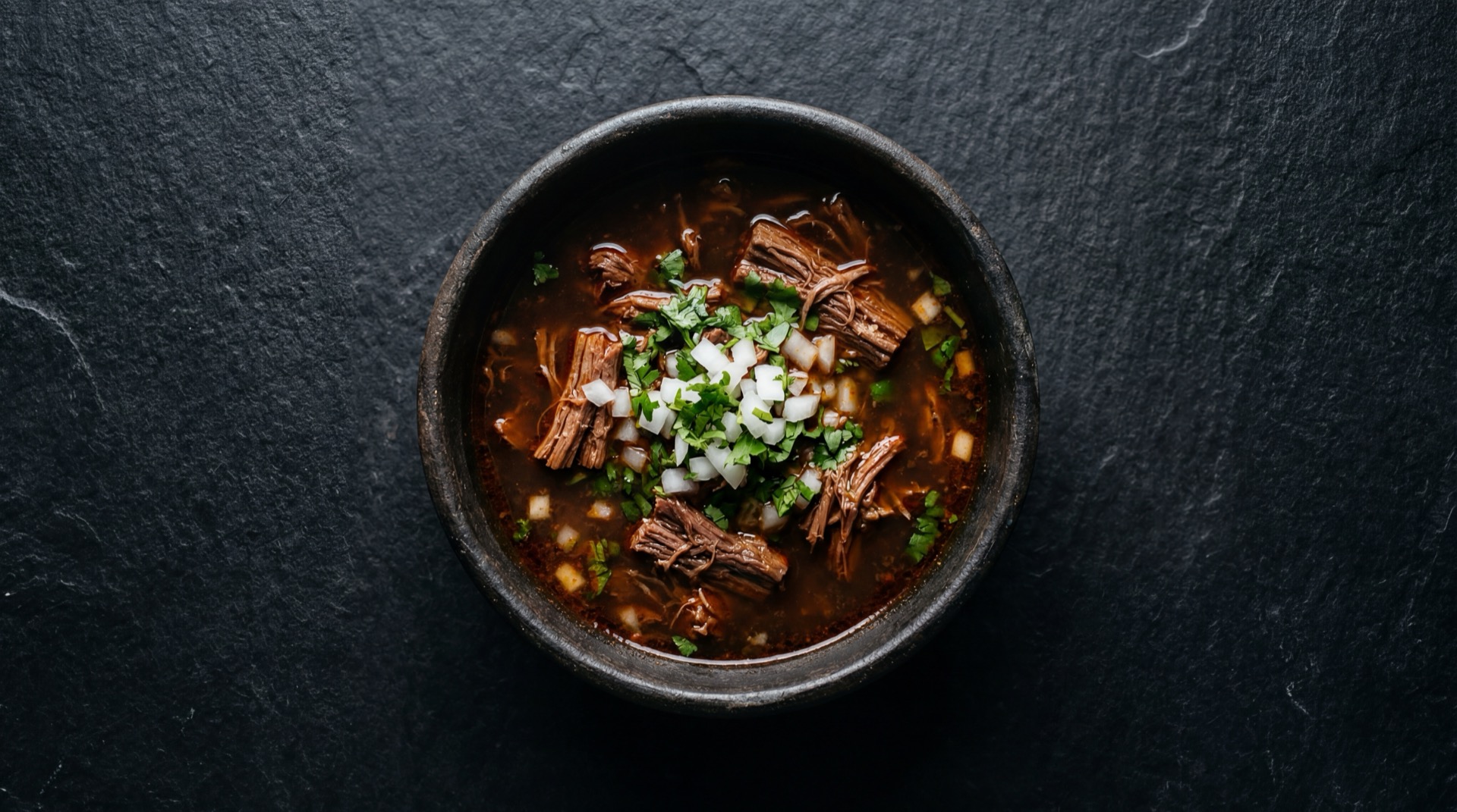 Birria de res version saludable con corte magro de res en consome desgrasado con verduras frescas y limon verde
