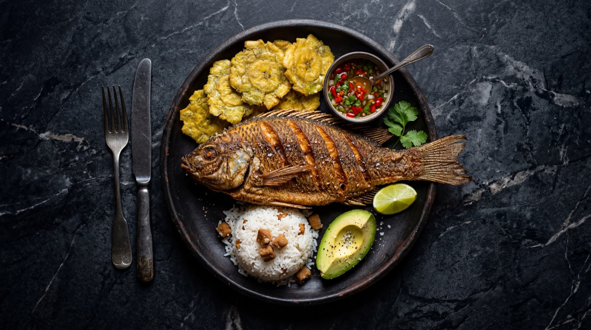 Bocachico frito dorado y crujiente del rio Magdalena con limon verde y patacones