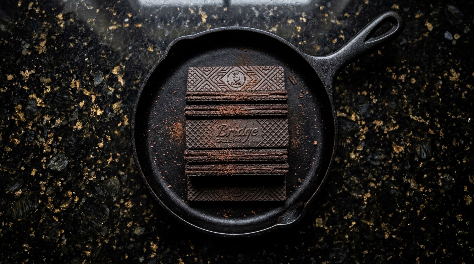 Galletas Bridge de Noel, wafer de chocolate con crema sobre mesa de marmol oscuro