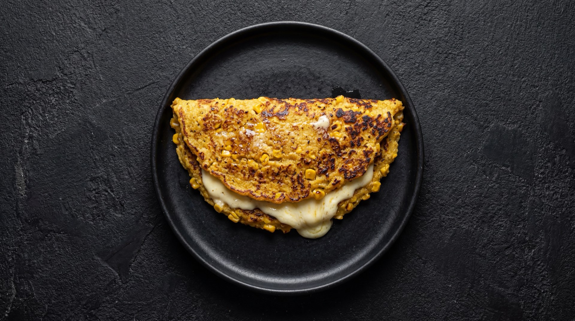 Cachapa venezolana version saludable mas delgada con menos queso de mano y sin cochino frito, acompanada de ensalada verde fresca