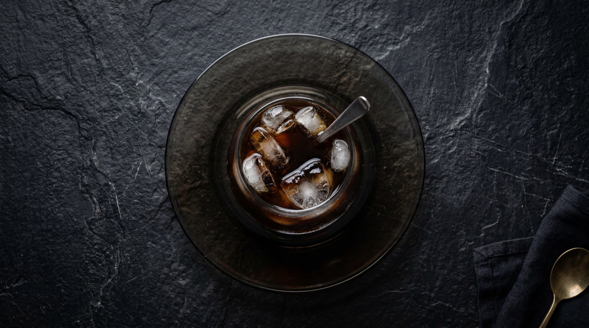 Cafe negro Sello Rojo sin azucar en taza de ceramica oscura, con canela en rama y stevia natural al lado como alternativas saludables