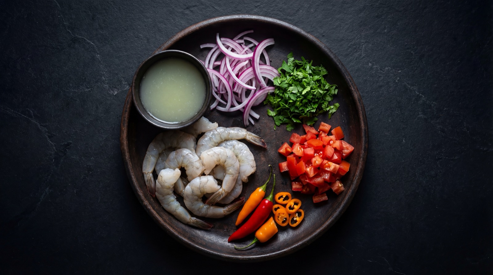 Ingredientes del ceviche colombiano: camaron, pescado, limon, cebolla morada, cilantro, aji y tomate