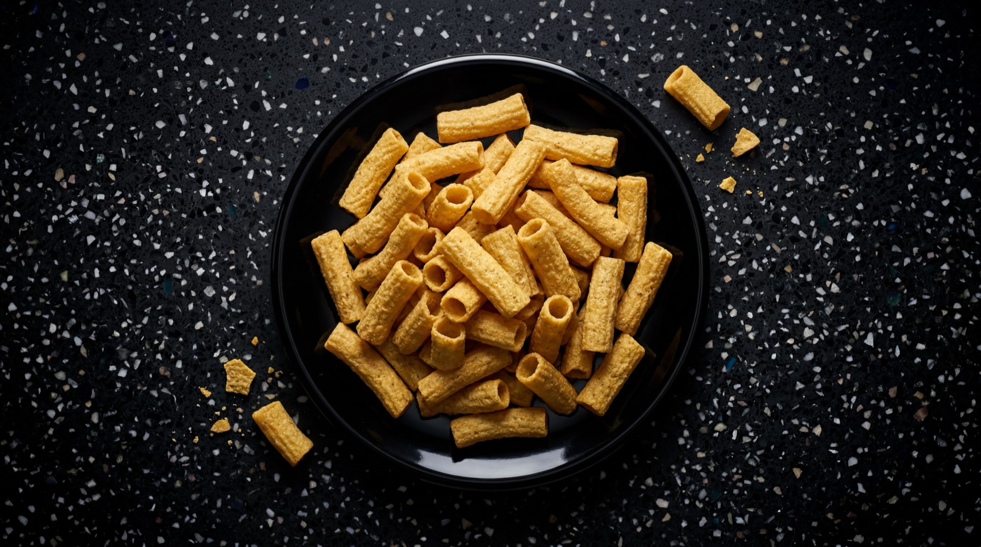 Choclitos de Frito Lay Colombia, tubitos de maiz frito crujientes en paquete verde sobre mesa de marmol oscuro