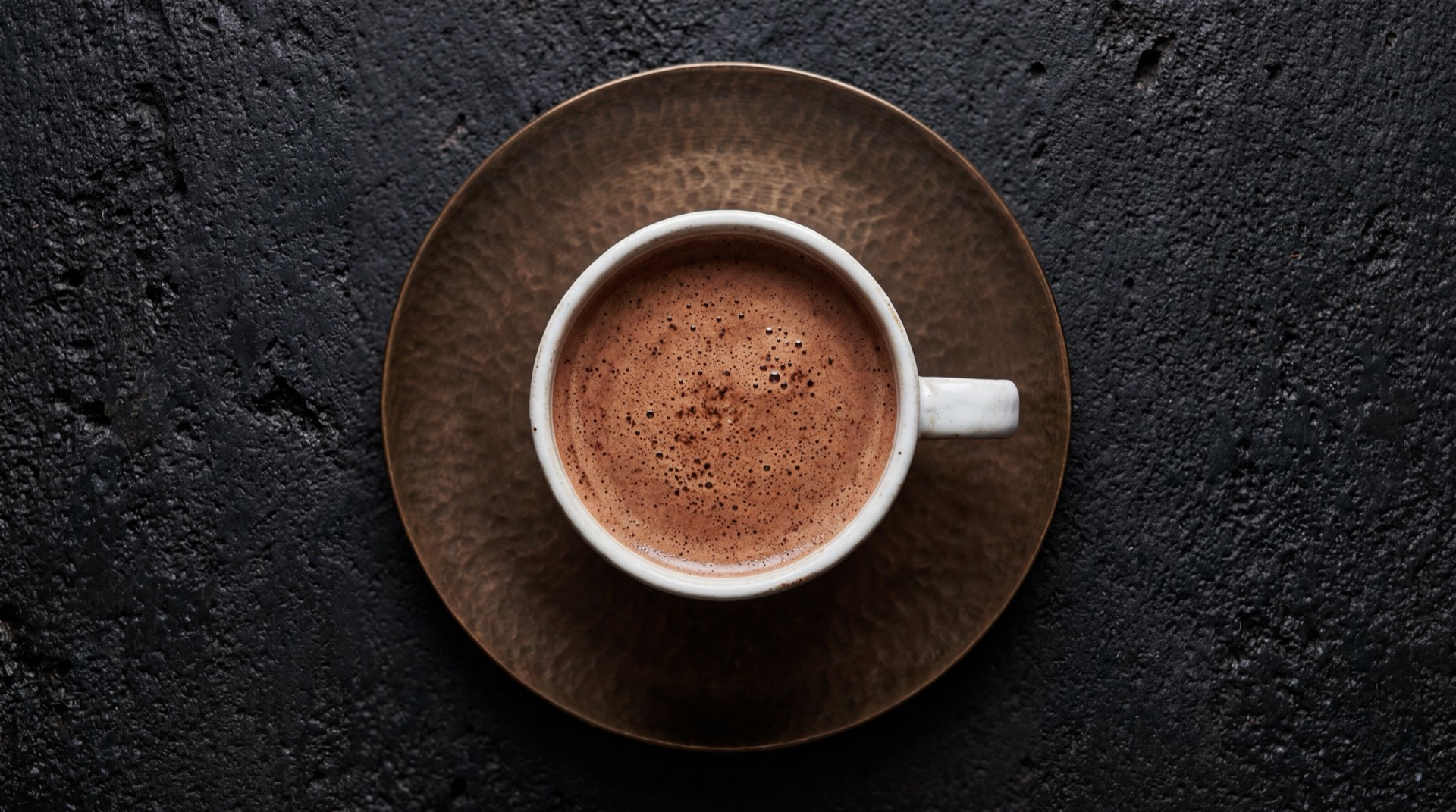 Taza de chocolate Corona preparado con leche descremada sin azucar anadida, con canela en rama y clavos de olor