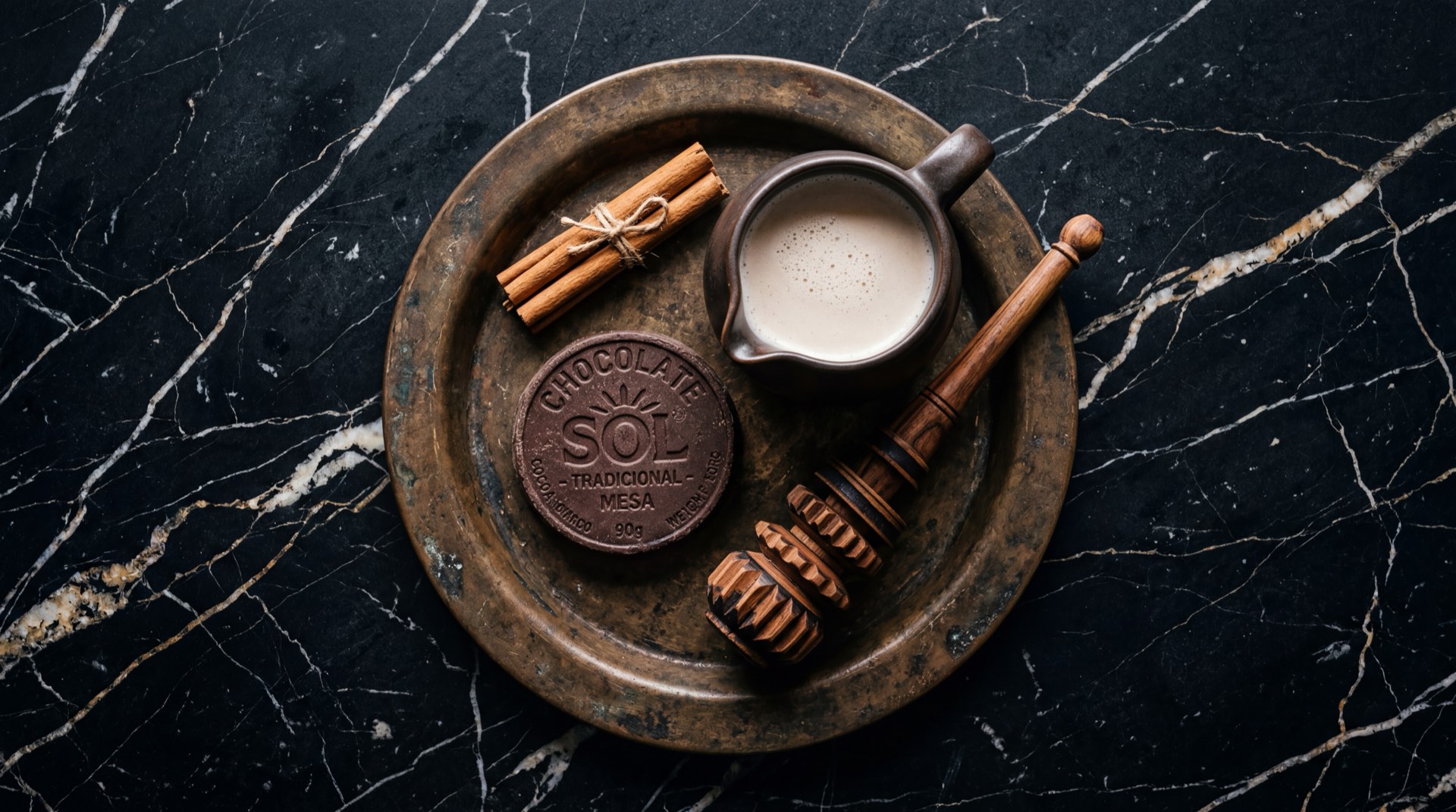 Ingredientes para chocolate caliente colombiano: pastilla de Chocolate Sol partida en trozos, taza de leche entera fresca, raja de canela en rama seca y molinillo de madera colombiano