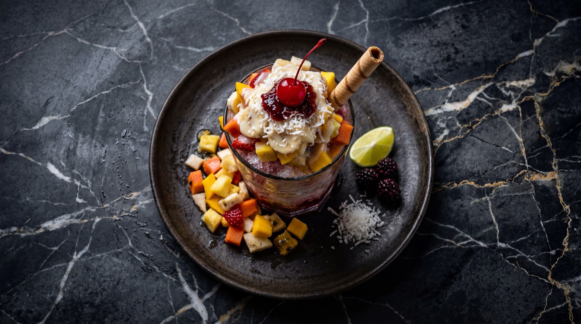 Cholado caleno con hielo raspado, frutas frescas tropicales, crema de leche, leche condensada y siropes de colores