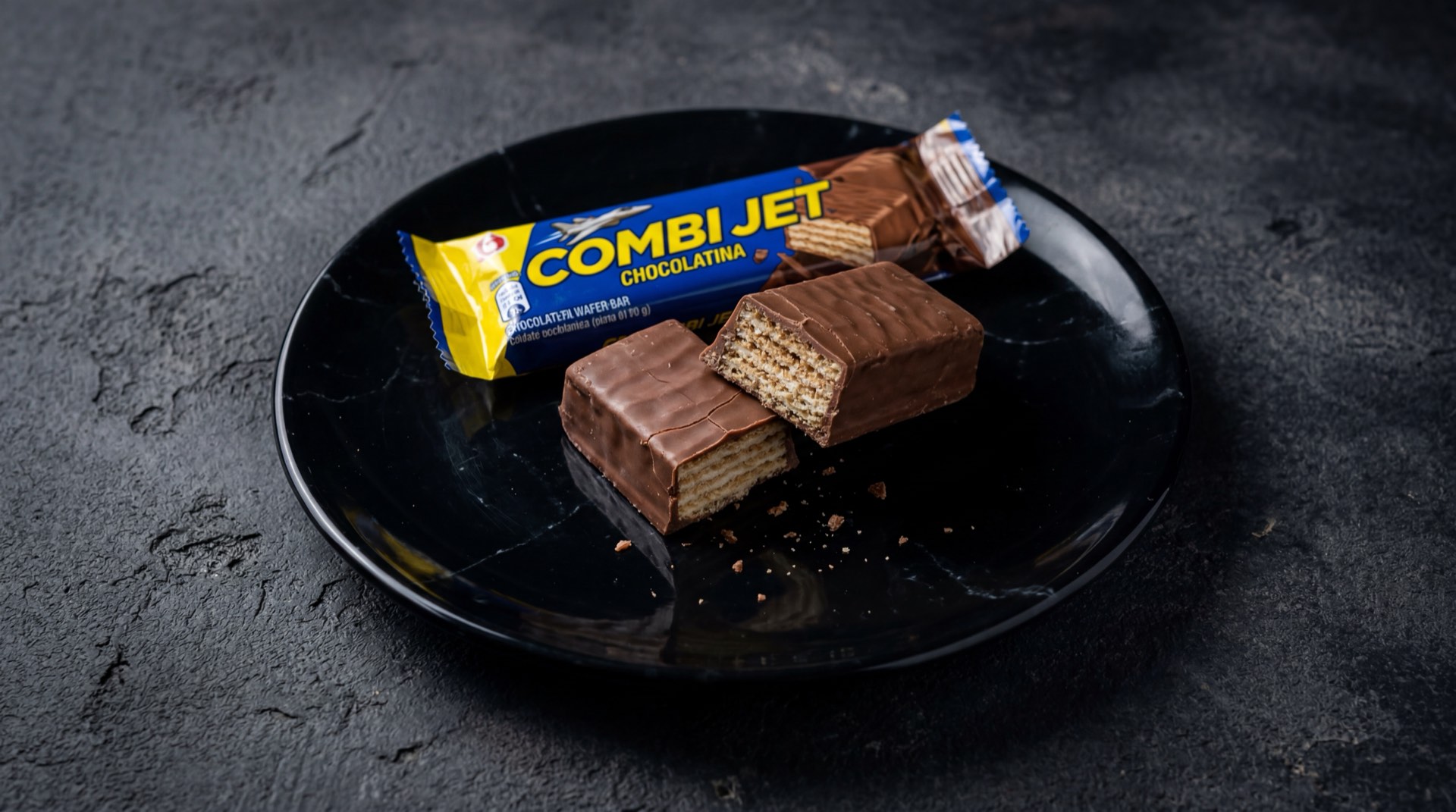 Combi Jet de Nacional de Chocolates, barra de wafer cubierta de chocolate con leche sobre superficie de marmol negro