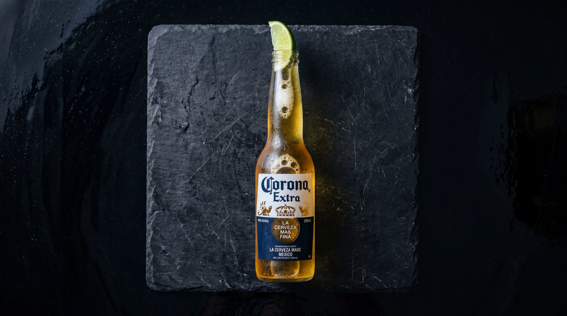 Corona cerveza botella sobre mesa oscura