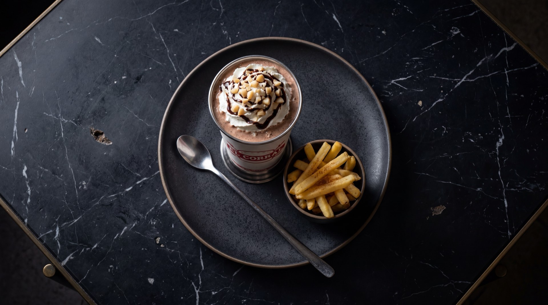 Malteada clasica de El Corral servida en vaso alto con crema batida, helado de vainilla y sirope de chocolate