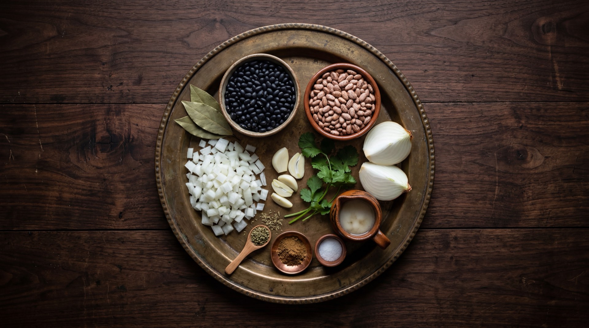 Ingredientes de los frijoles refritos mexicanos: frijoles pintos cocidos en su caldo, manteca de cerdo, cebolla blanca picada, dientes de ajo pelados, comino molido, sal gruesa y queso fresco desmoronado