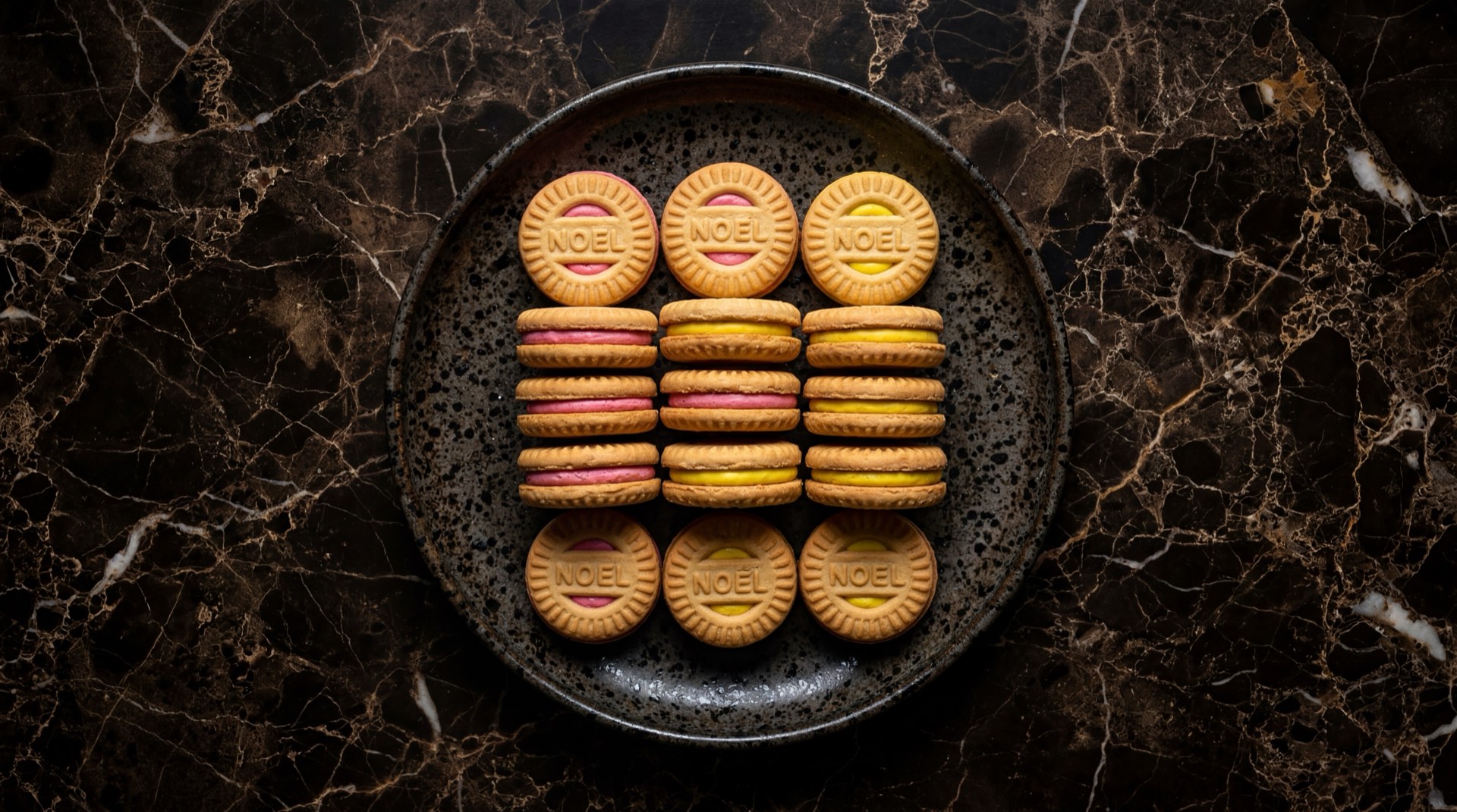 Galletas Festival de Noel sabor vainilla, fresa, chocolate y limon sobre plato de ceramica oscura en mesa de ebano