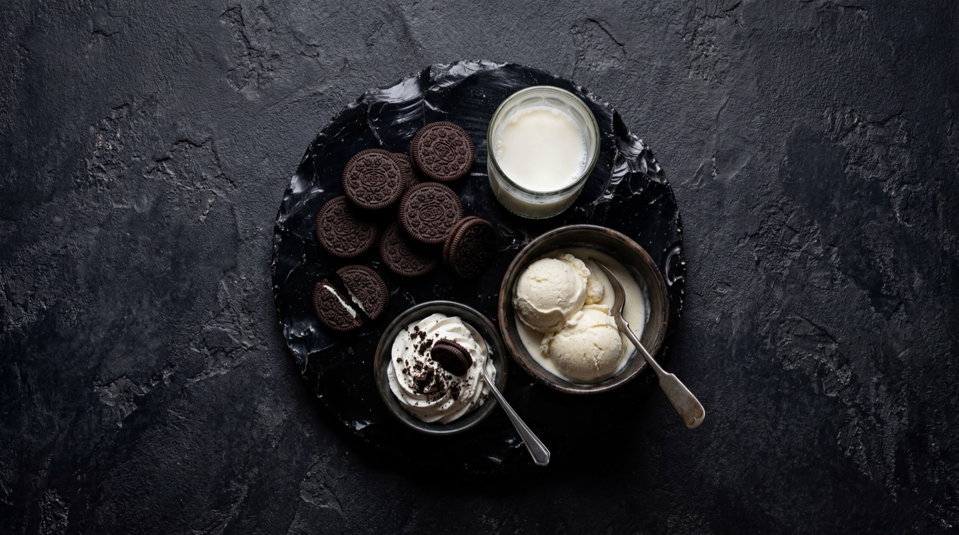 Galletas Oreo desarmadas mostrando las dos tapas de galleta de chocolate amargo y el relleno de crema de vainilla blanca separado, junto a harina de trigo y cacao en polvo