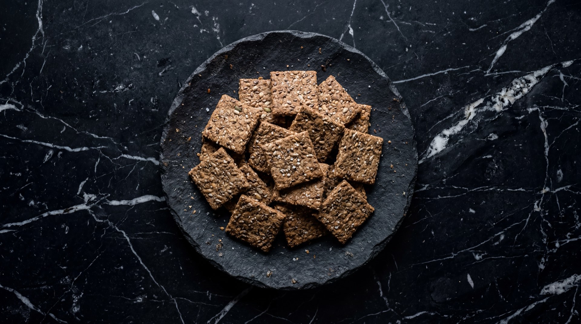 Version saludable de snack con galletas Saltinas integral de Noel, queso fresco campesino untado y rodajas de aguacate maduro Hass