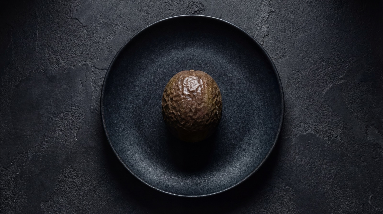 Granadilla entera y abierta mostrando cascara, pulpa y semillas