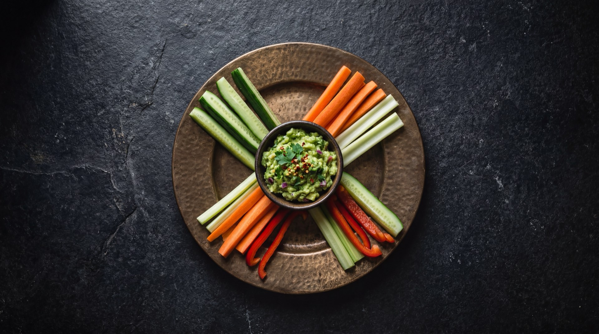 Guacamole mexicano version saludable servido con bastones de jicama fresca, zanahoria y pepino en vez de totopos fritos