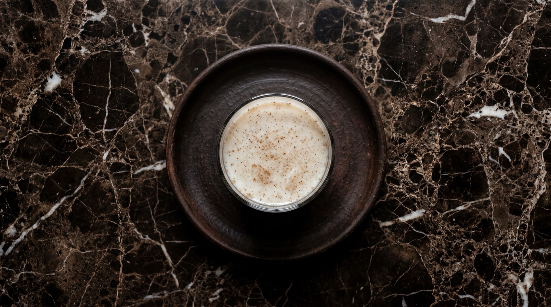 Horchata mexicana de arroz con canela en vaso de vidrio con hielo sobre mesa de marmol oscuro