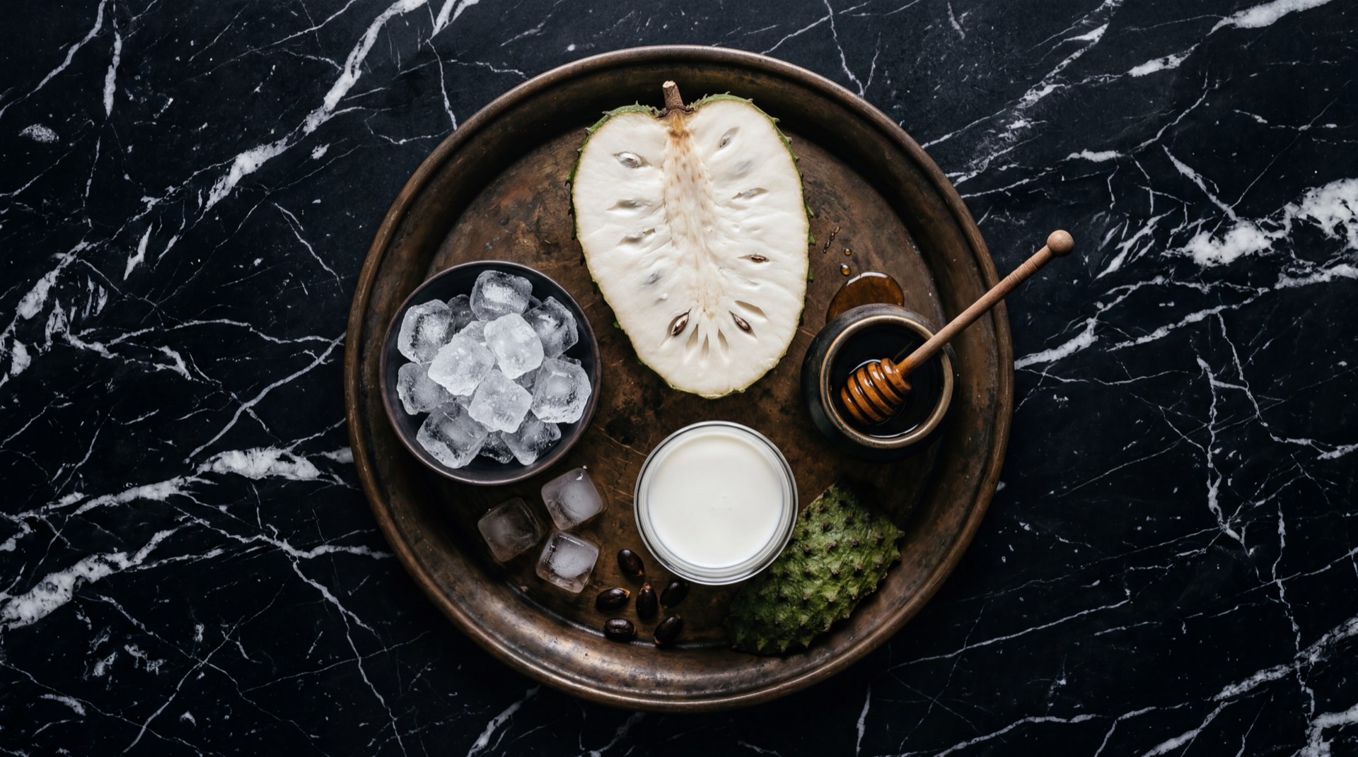 Caja de jugo Hit de guanabana junto a guanabana fresca abierta mostrando la pulpa blanca cremosa sobre superficie oscura