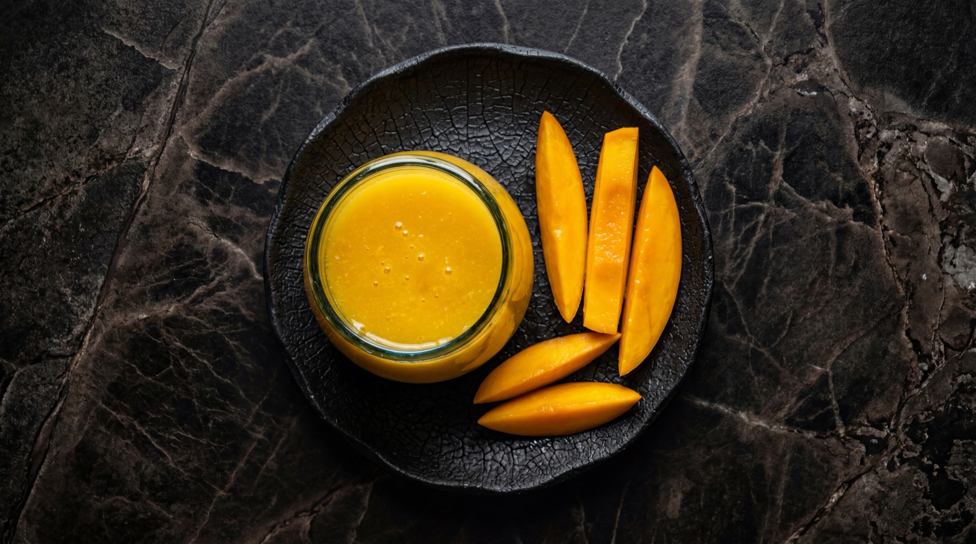 Vaso de jugo de mango natural hecho en casa con mango fresco cortado y hielo como alternativa saludable al jugo Hit