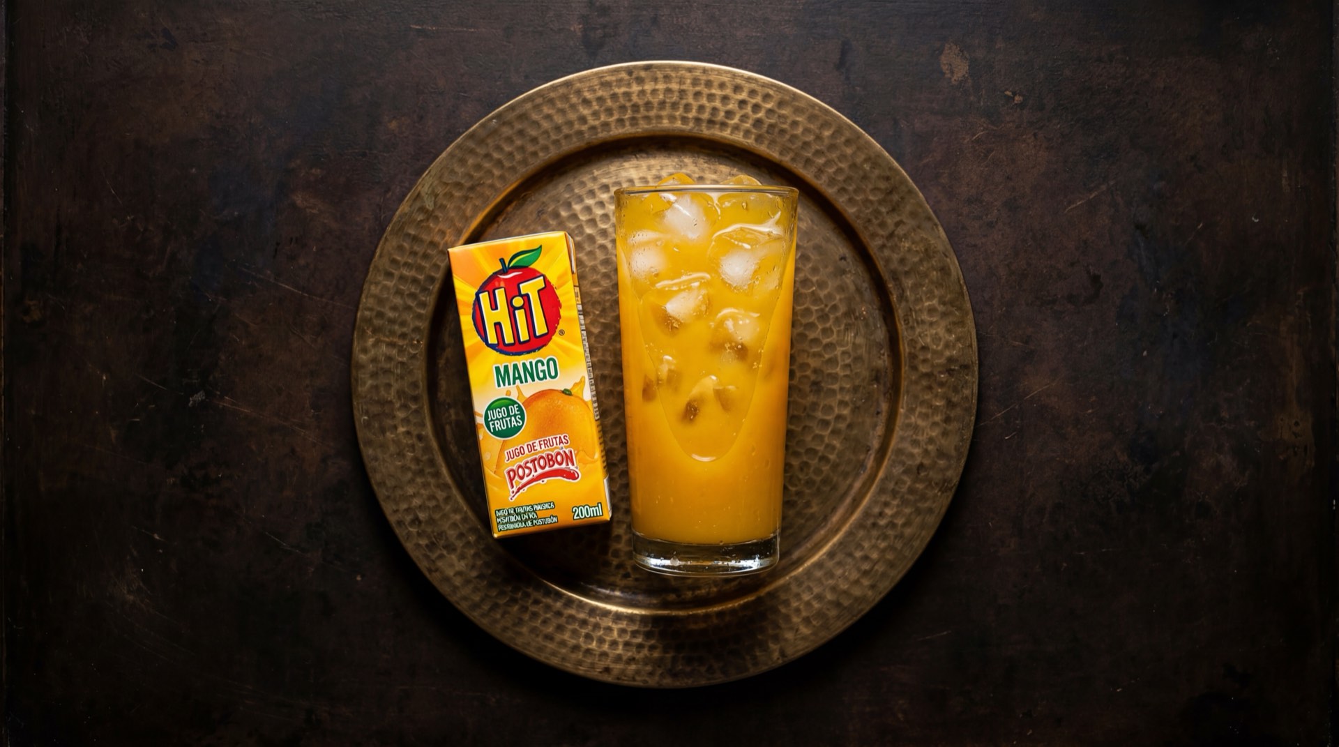 Caja de jugo Hit de mango de Postobon sobre superficie oscura