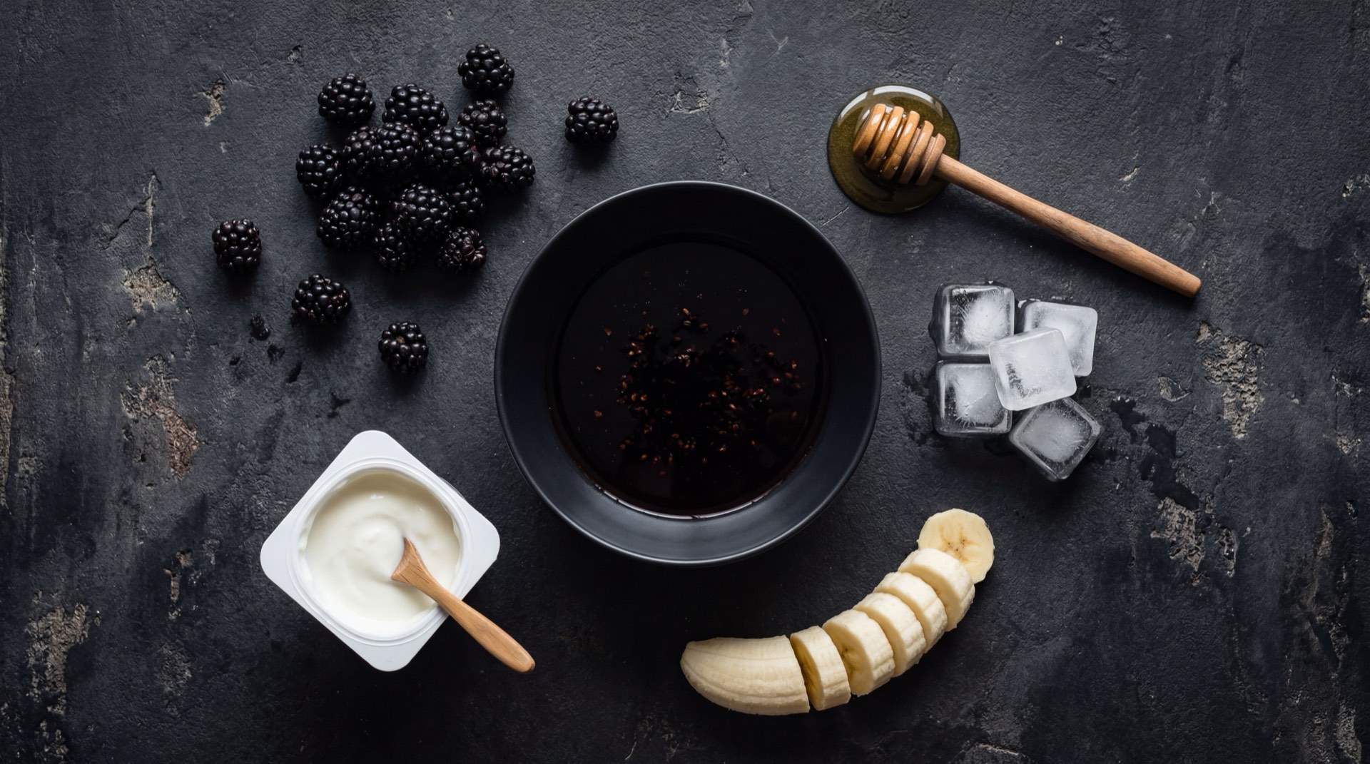 Caja de jugo Hit de mora abierta junto a moras frescas de Castilla sobre superficie oscura