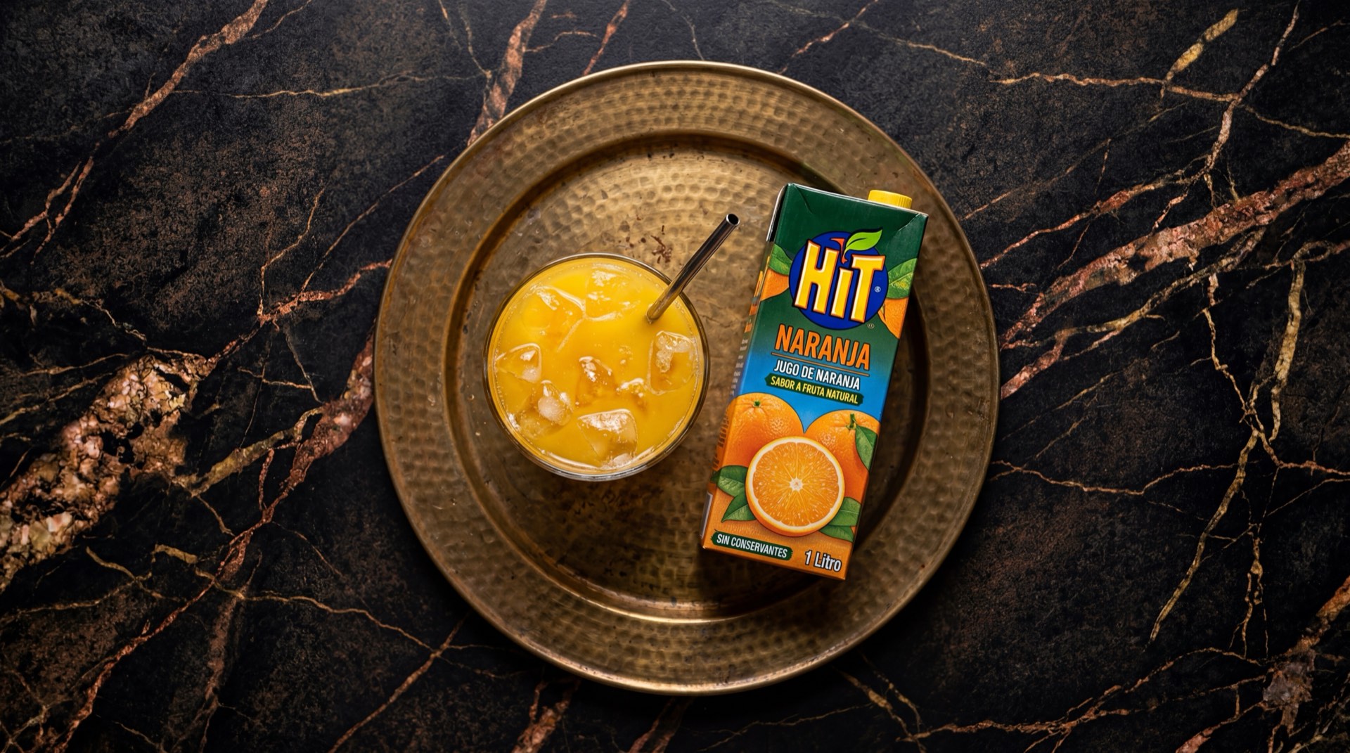 Caja de jugo Hit de naranja de Postobon sobre superficie oscura