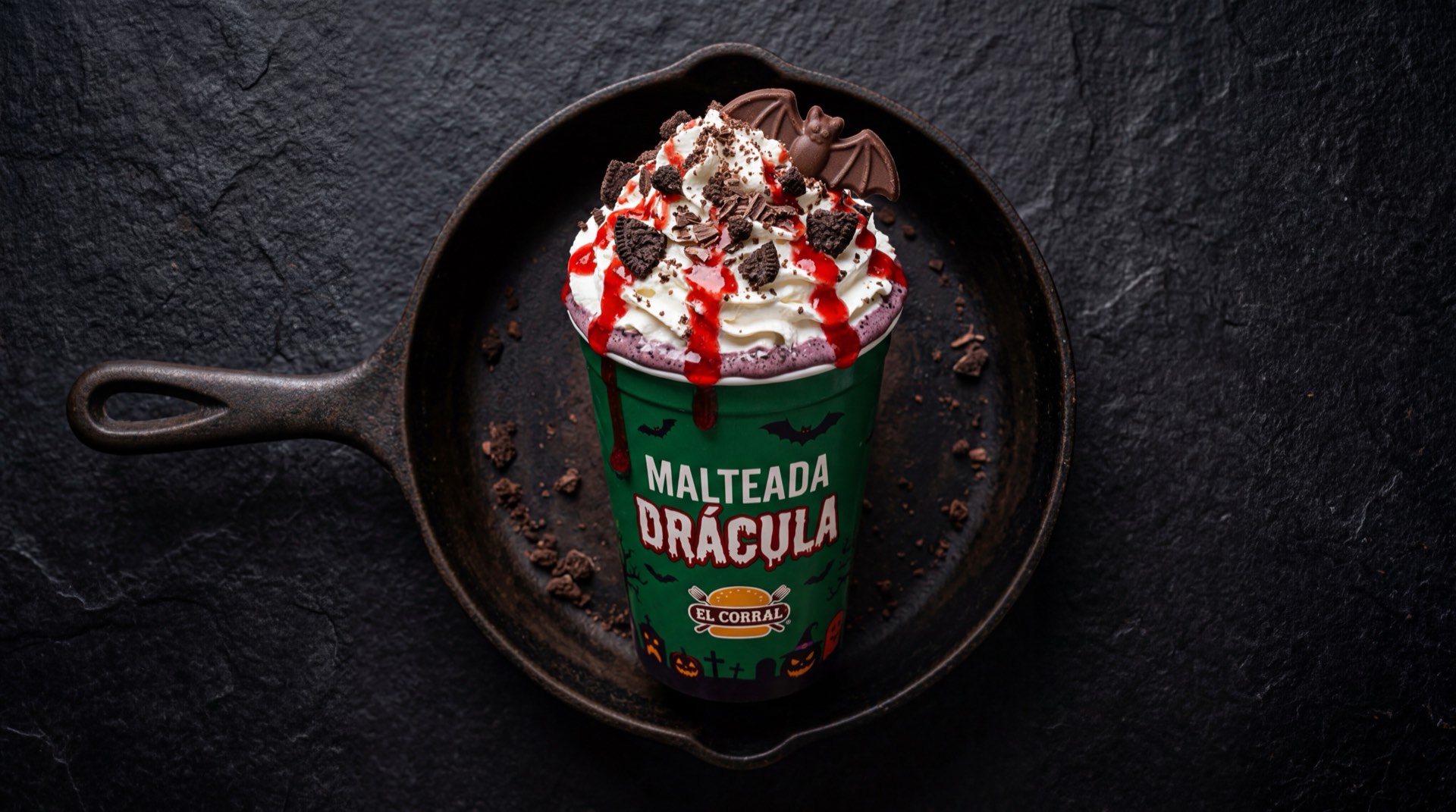 Malteada Dracula de El Corral con chocolate oscuro, galleta Oreo triturada, crema batida espesa y salsa de chocolate tipo fudge en vaso alto de vidrio