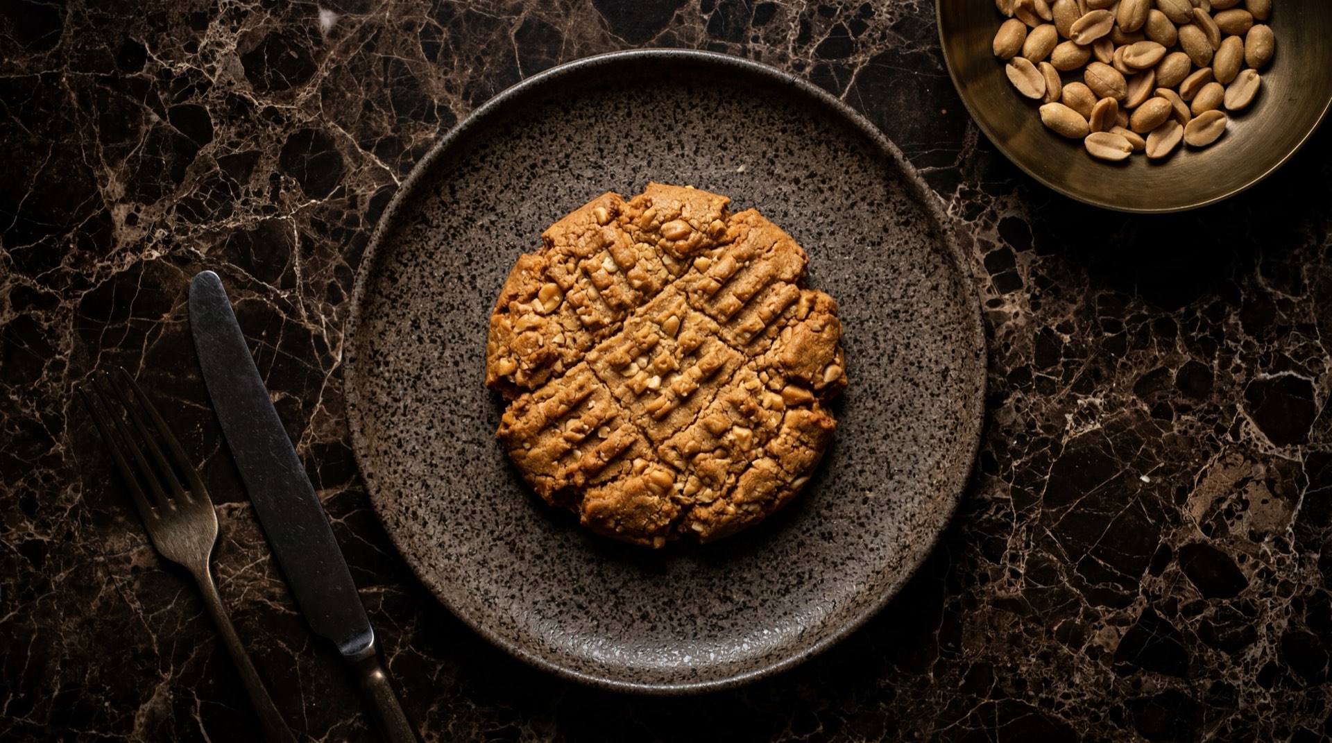 Galleta Mana de Ramo, galleta crocante de mani colombiana sobre mesa de marmol oscuro
