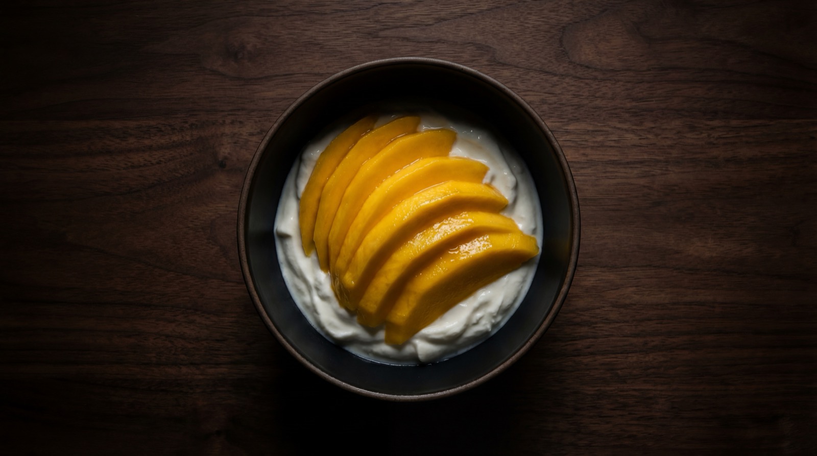 Bowl de mango fresco con yogurt griego y granola, merienda tropical saludable