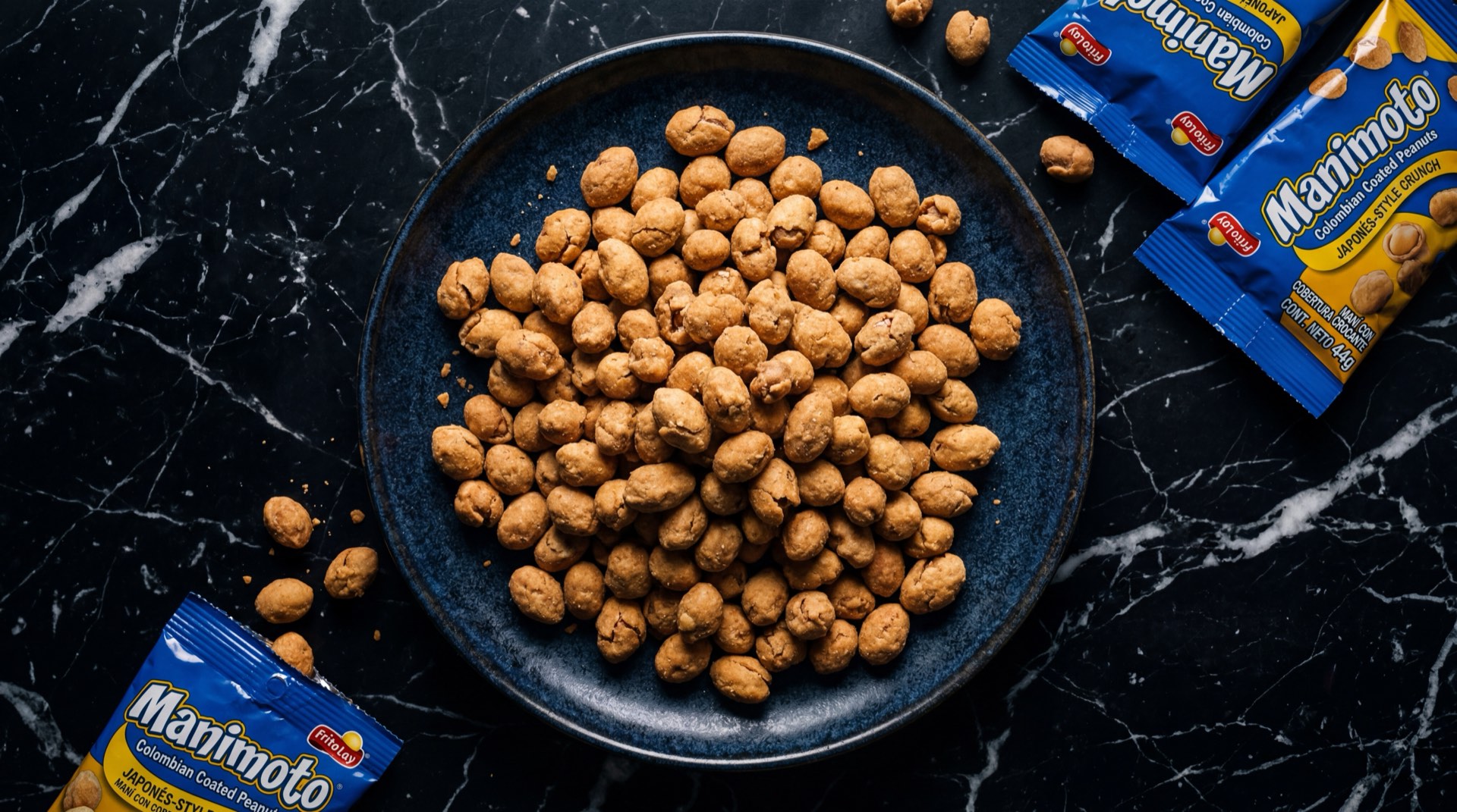 Manimoto de Frito Lay, mani recubierto crujiente estilo japones servido en plato de ceramica oscura sobre mesa de marmol negro