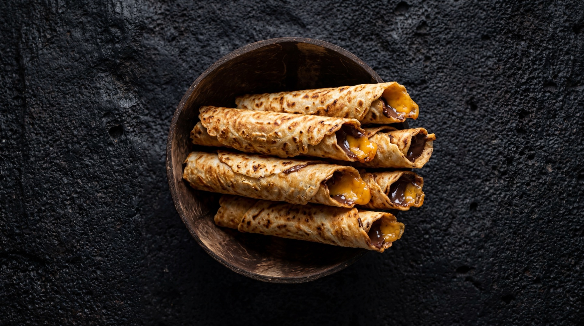 Marquesitas Yucatecas mexicano tradicional servido en plato oscuro sobre mesa de marmol negro