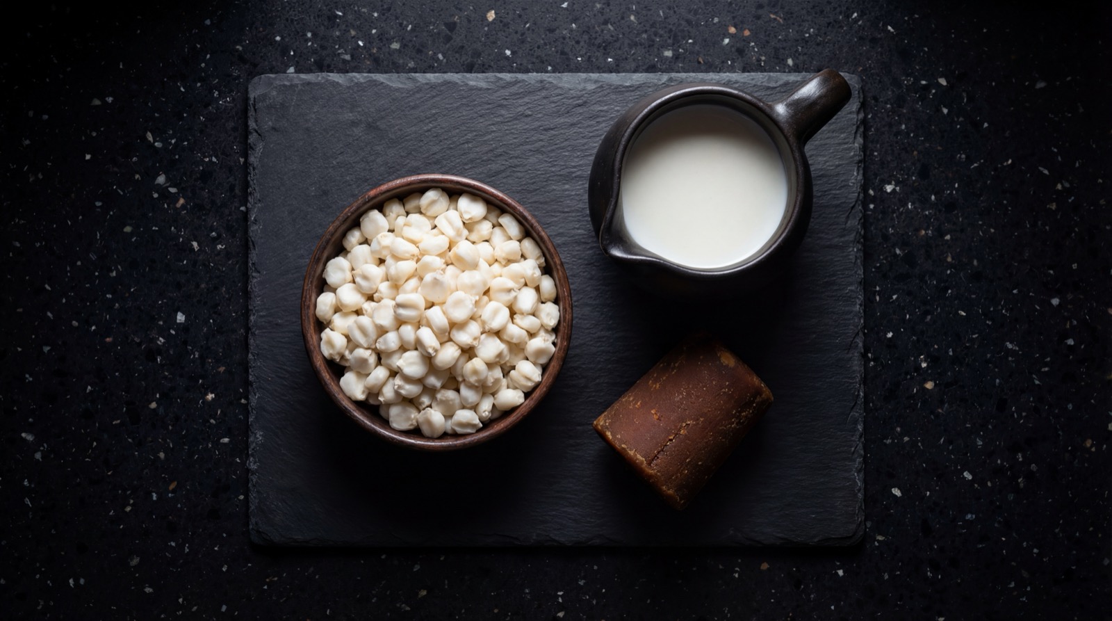 Ingredientes de la mazamorra colombiana: maiz trillado, panela, leche y canela