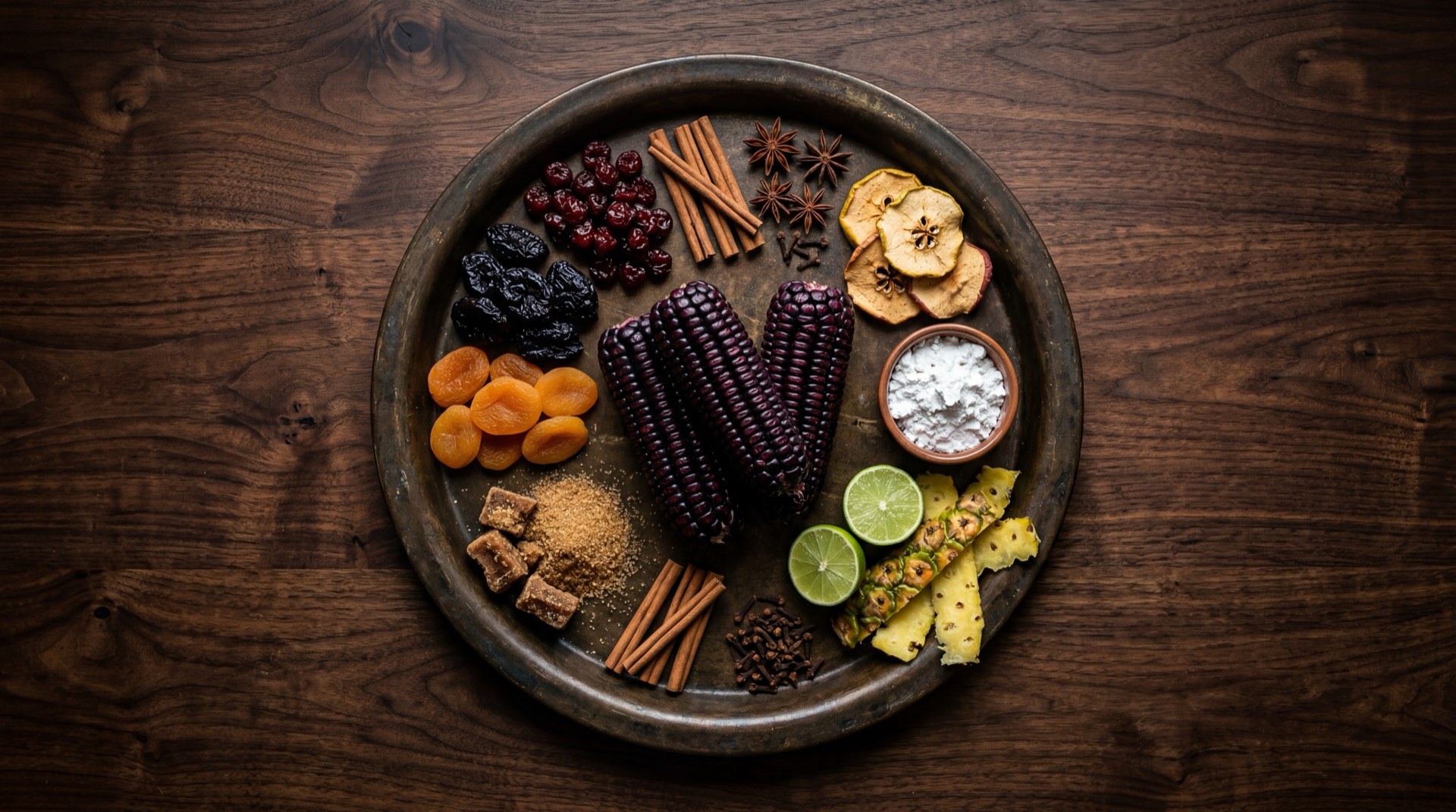 Ingredientes de la mazamorra morada: mazorcas de maiz morado seco, pina fresca en cubos, membrillos frescos, guindones secos, orejones de durazno secos, rajas de canela entera, clavos de olor, cascara de naranja, chuño de camote y limones verdes peruanos