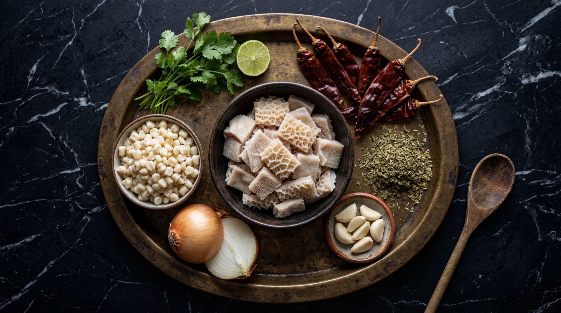 Ingredientes para menudo mexicano: panza de res mondongo limpia, pata de res, maiz pozolero precocido, chiles guajillo secos, chiles ancho secos, dientes de ajo pelados, cebolla blanca, oregano mexicano seco, comino molido