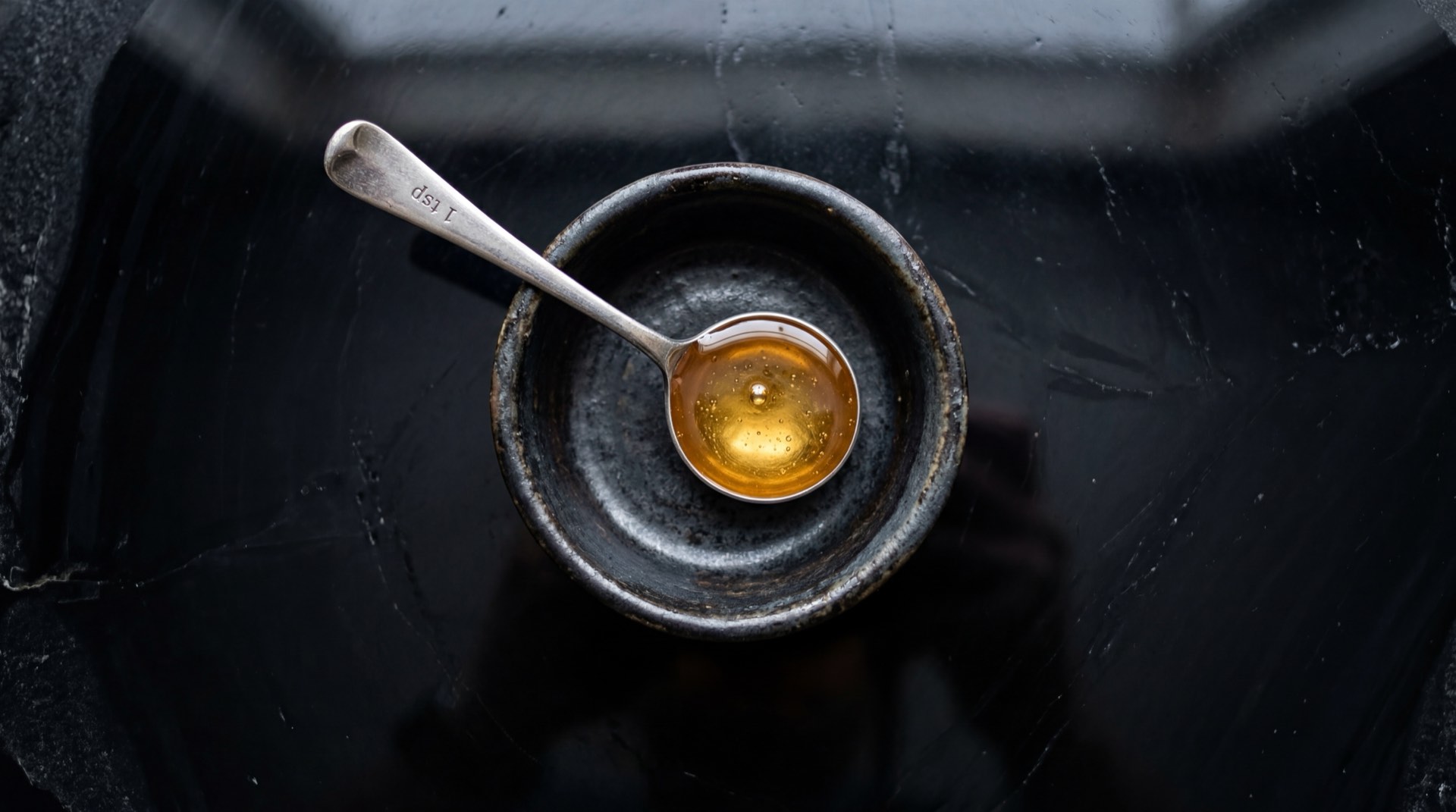 Cucharada de miel de abejas pura sobre yogurt griego con frutas, endulzante natural saludable