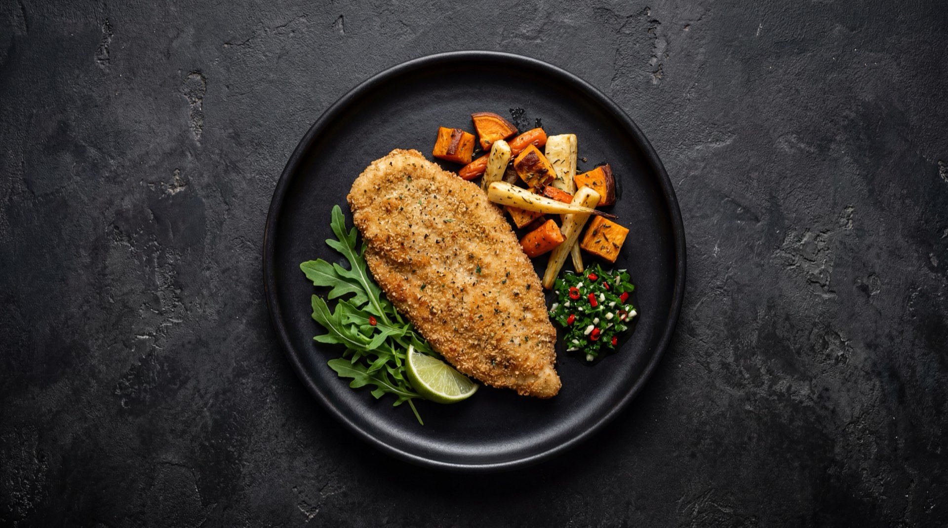 Milanesa argentina de pollo al horno crujiente con ensalada verde fresca sobre plato de ceramica oscura