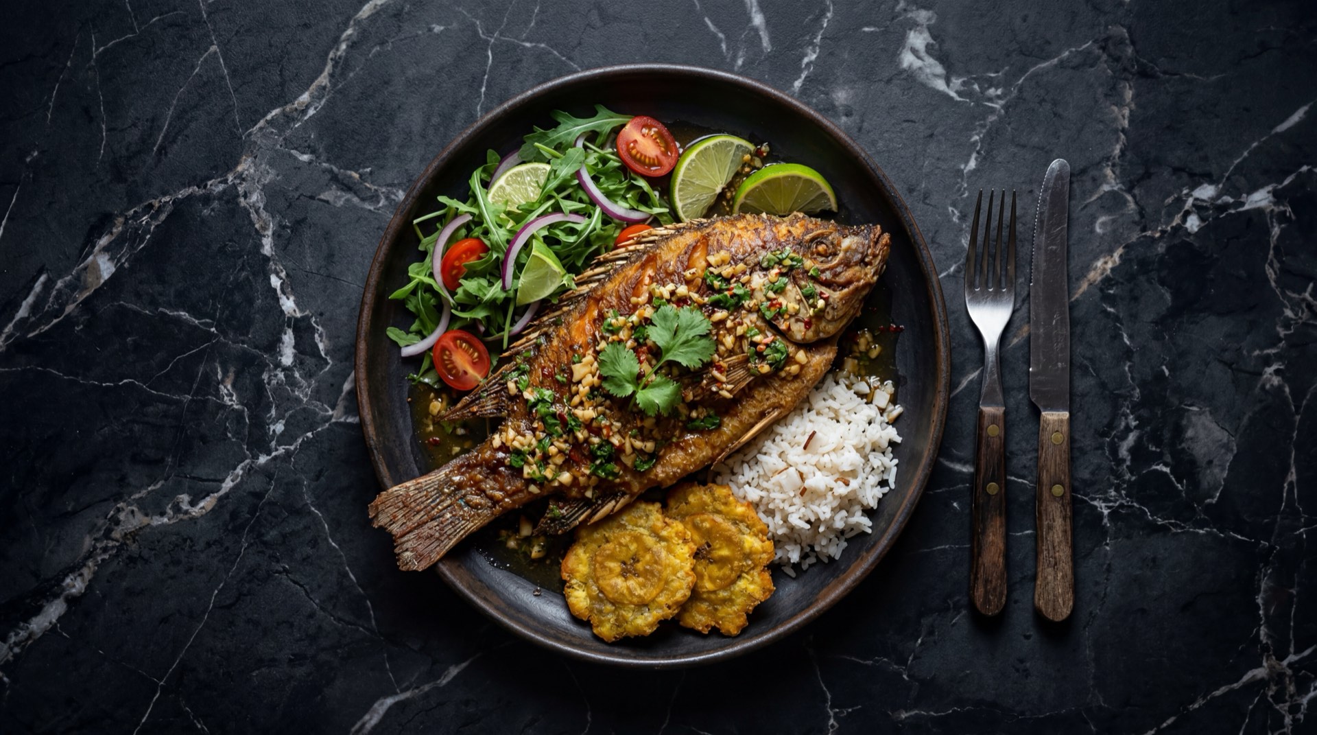 Mojarra al ajillo colombiana con mantequilla dorada, laminas de ajo, cilantro fresco y limon verde