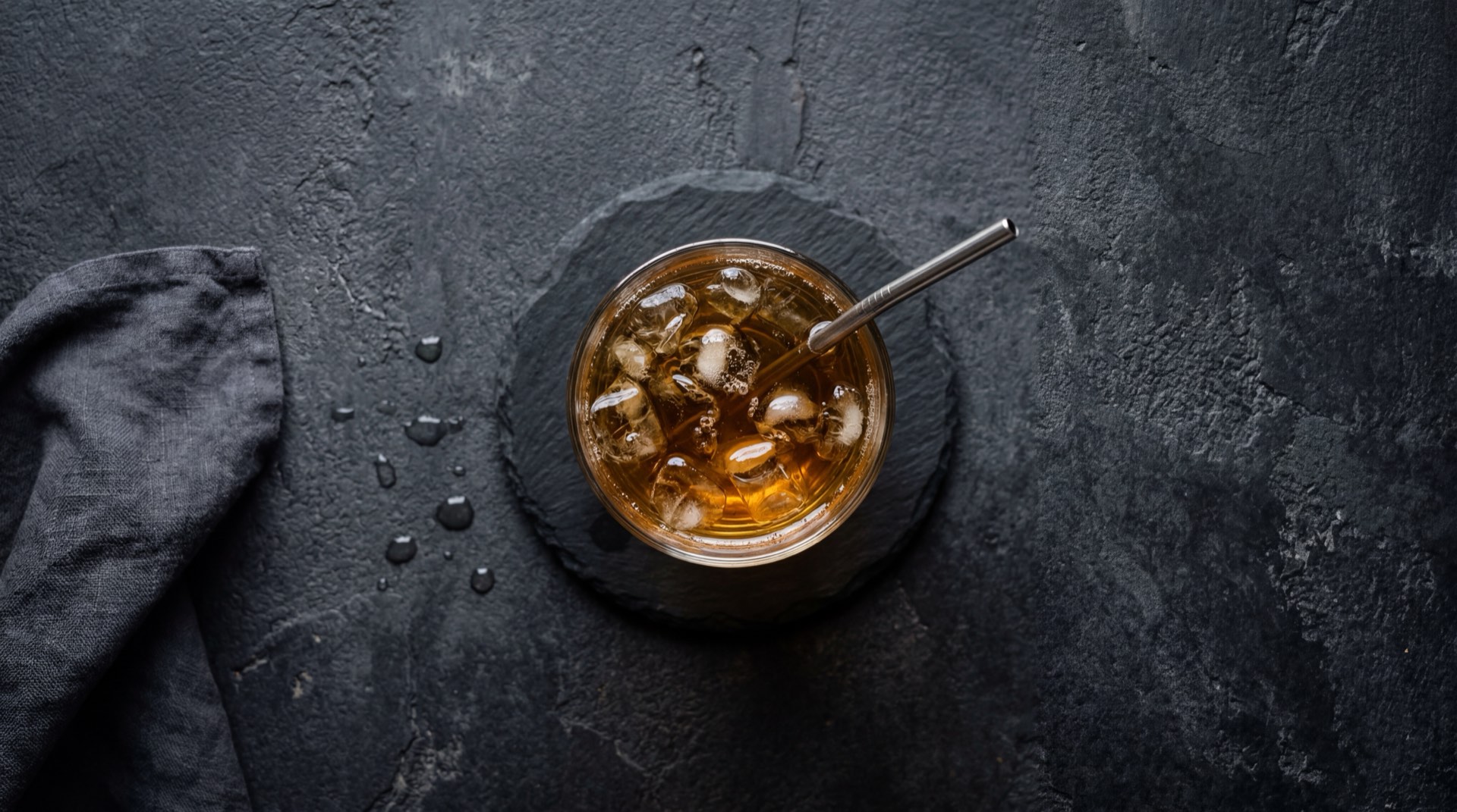 Te helado casero saludable con te negro real infusionado, rodajas de limon tahiti fresco, cubos de hielo cristalino y hojas de menta fresca