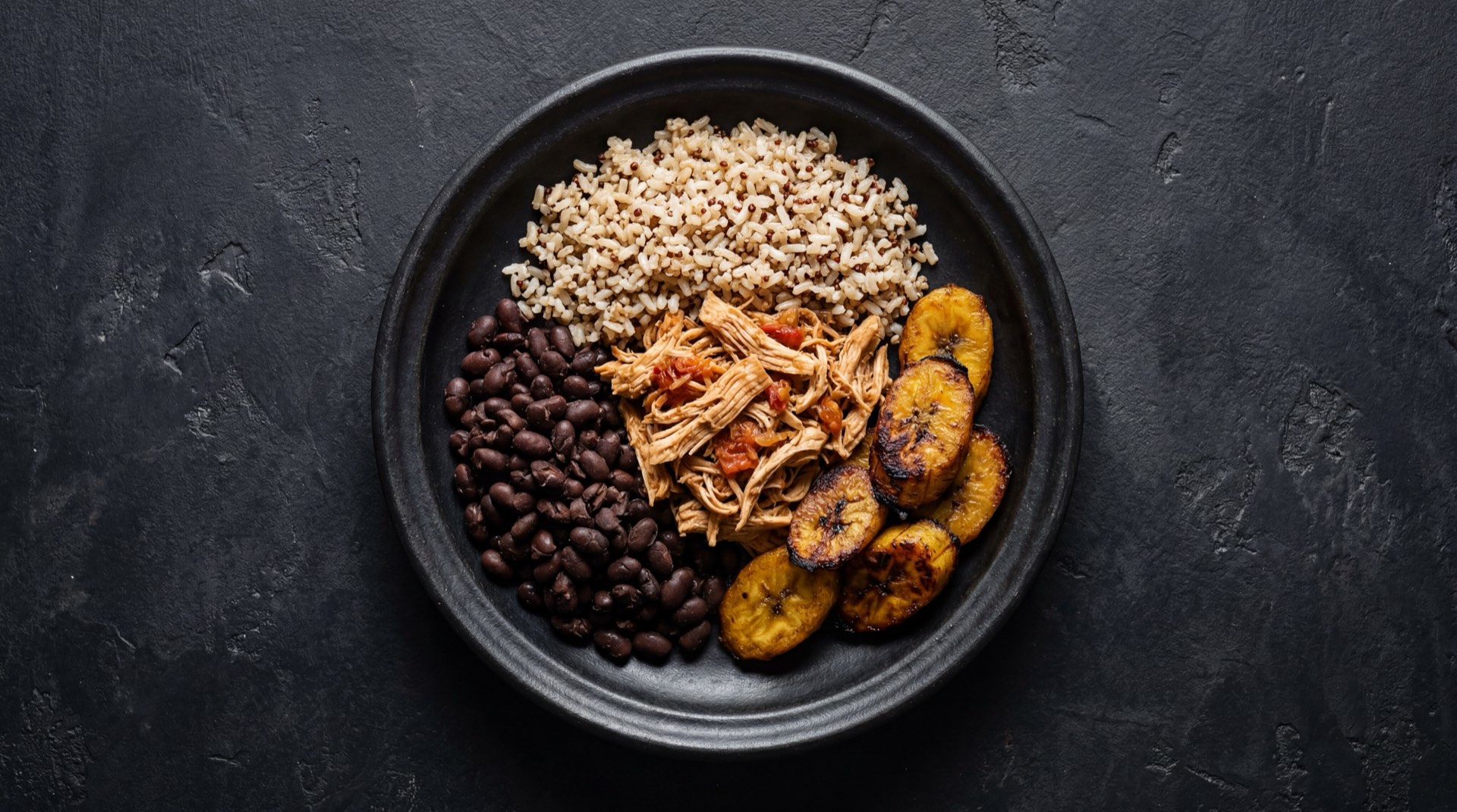 Pabellon criollo venezolano version saludable con arroz integral, tajadas de platano maduro al horno sin aceite y porcion reducida de caraotas negras