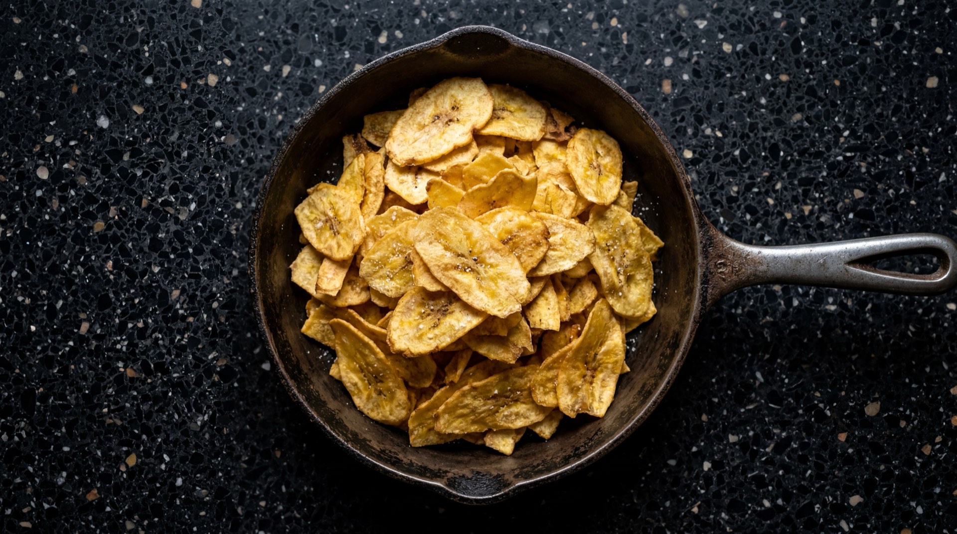 Platanitos Margarita de Frito Lay Colombia, chips de platano verde fritos crujientes en bolsa amarilla con acentos verdes sobre mesa oscura