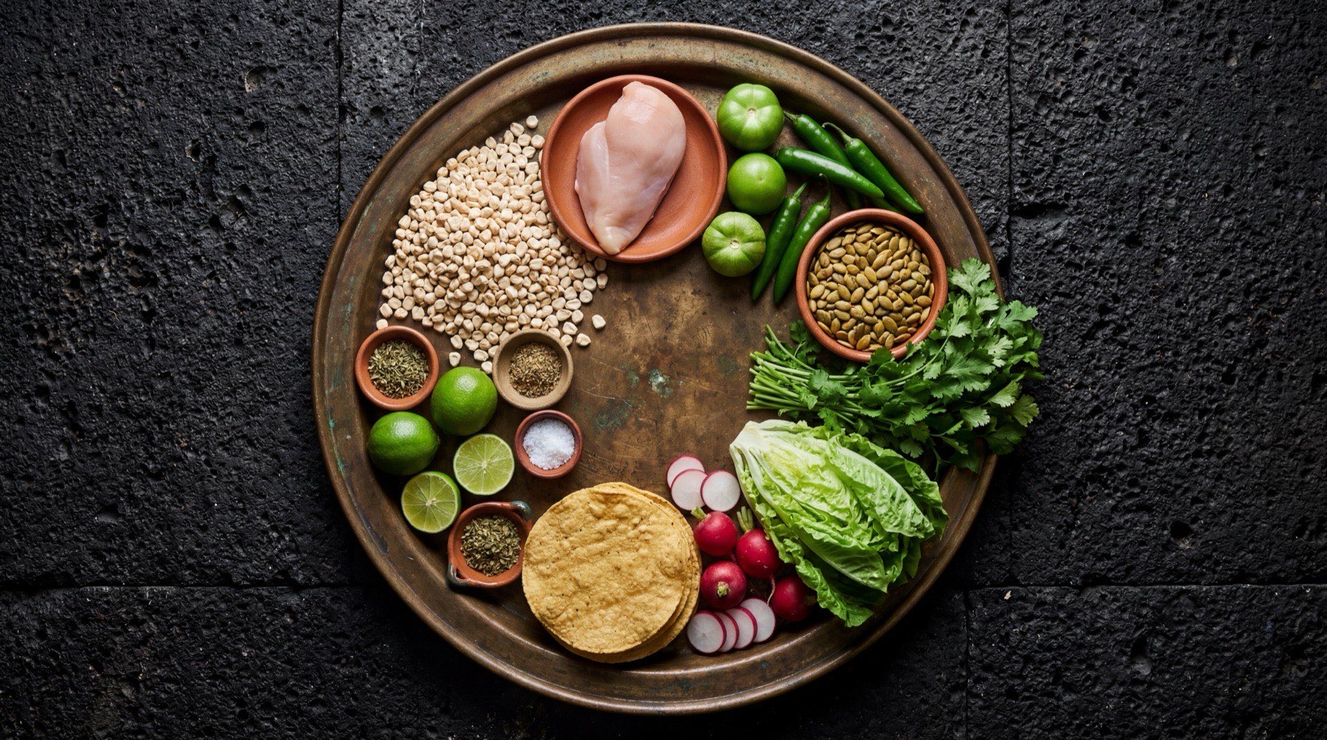 Ingredientes del pozole verde: maiz cacahuazintle precocido, pechuga de pollo con hueso cruda, tomatillos verdes frescos, chiles serranos verdes frescos, pepitas de calabaza crudas sin cascara, cilantro fresco con tallos, hojas de lechuga orejona, cebolla blanca y ajo entero