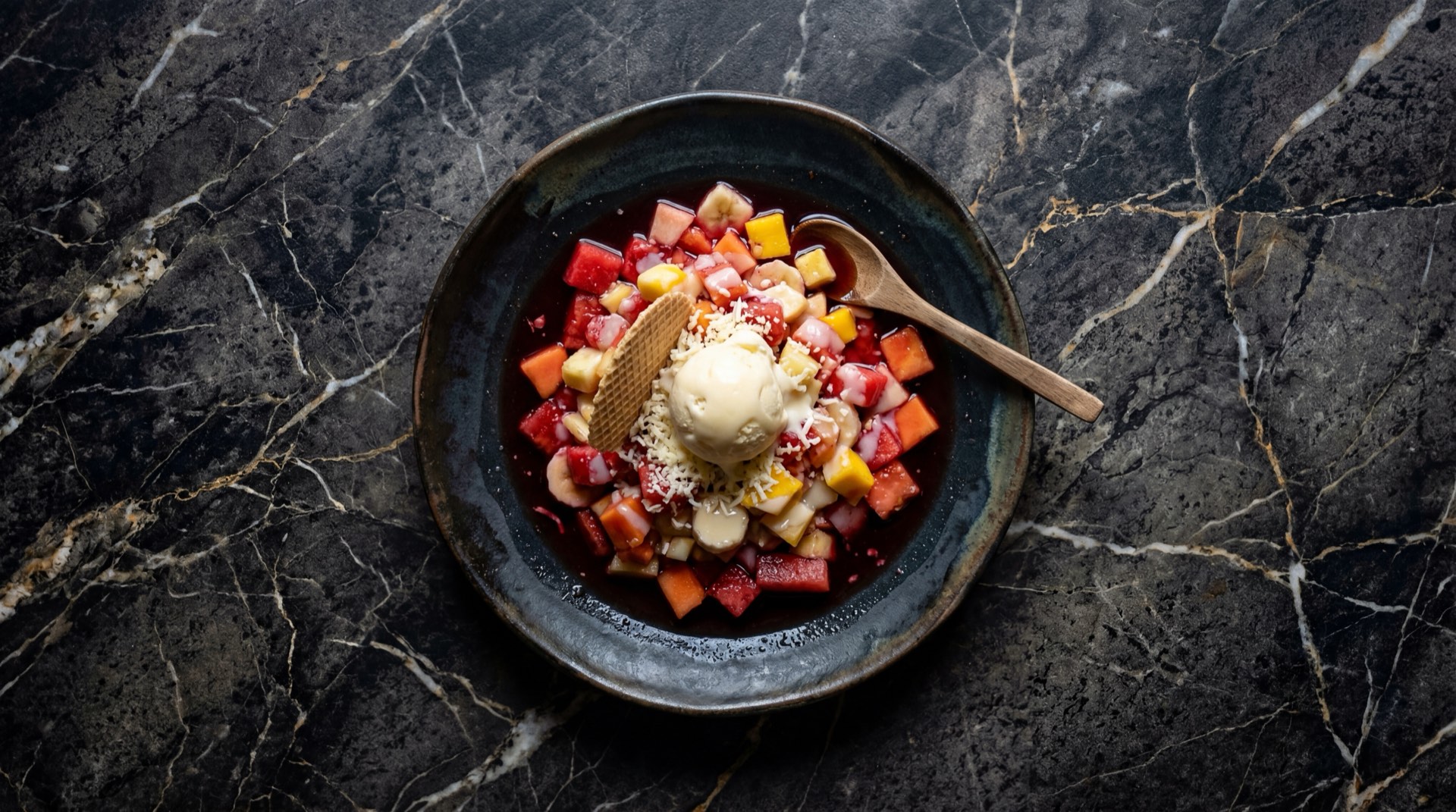 Salpicon colombiano de frutas con sandia roja, papaya madura, banano, mango y gaseosa