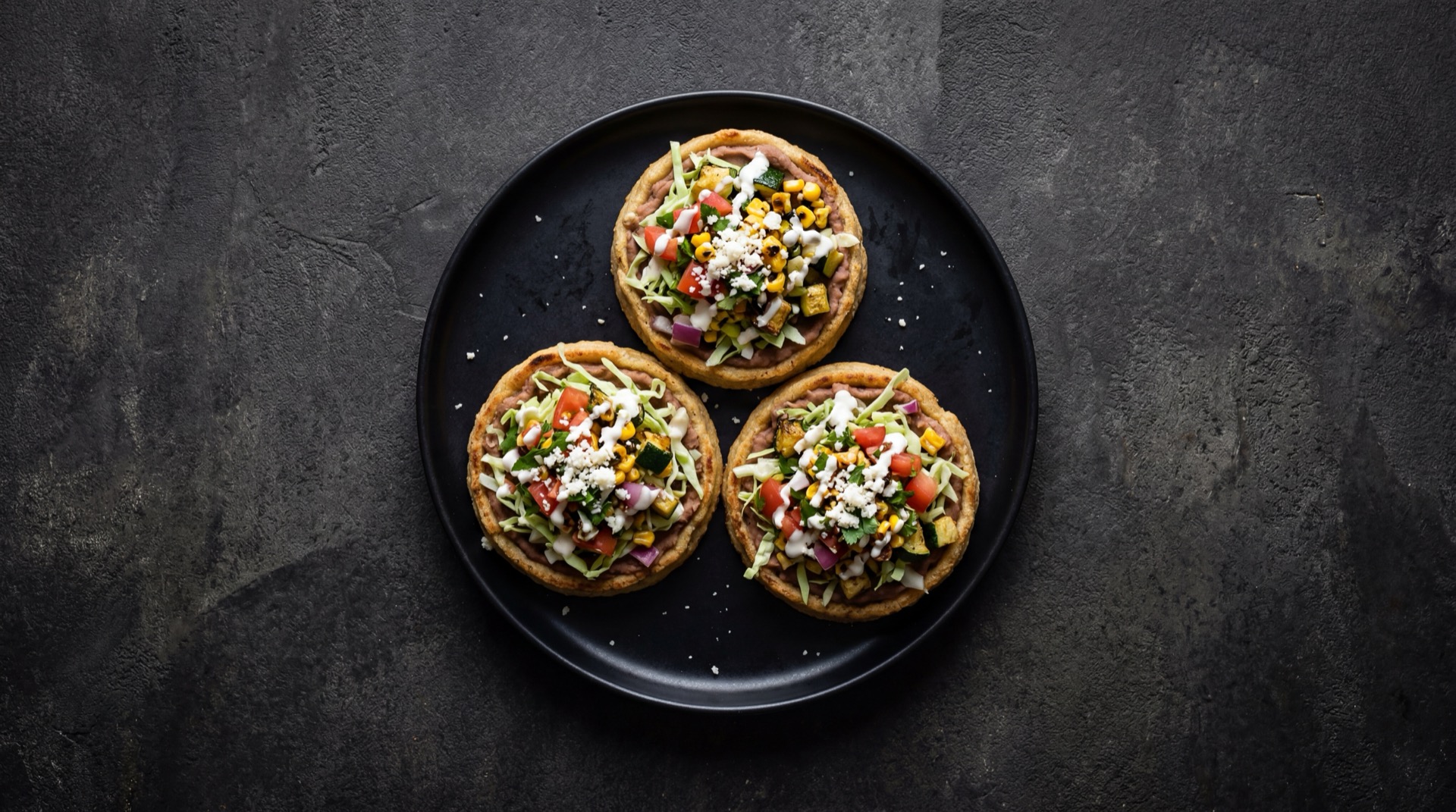 Sopes mexicanos version saludable con base cocida en comal sin freir, pollo deshebrado y abundante lechuga fresca sin crema