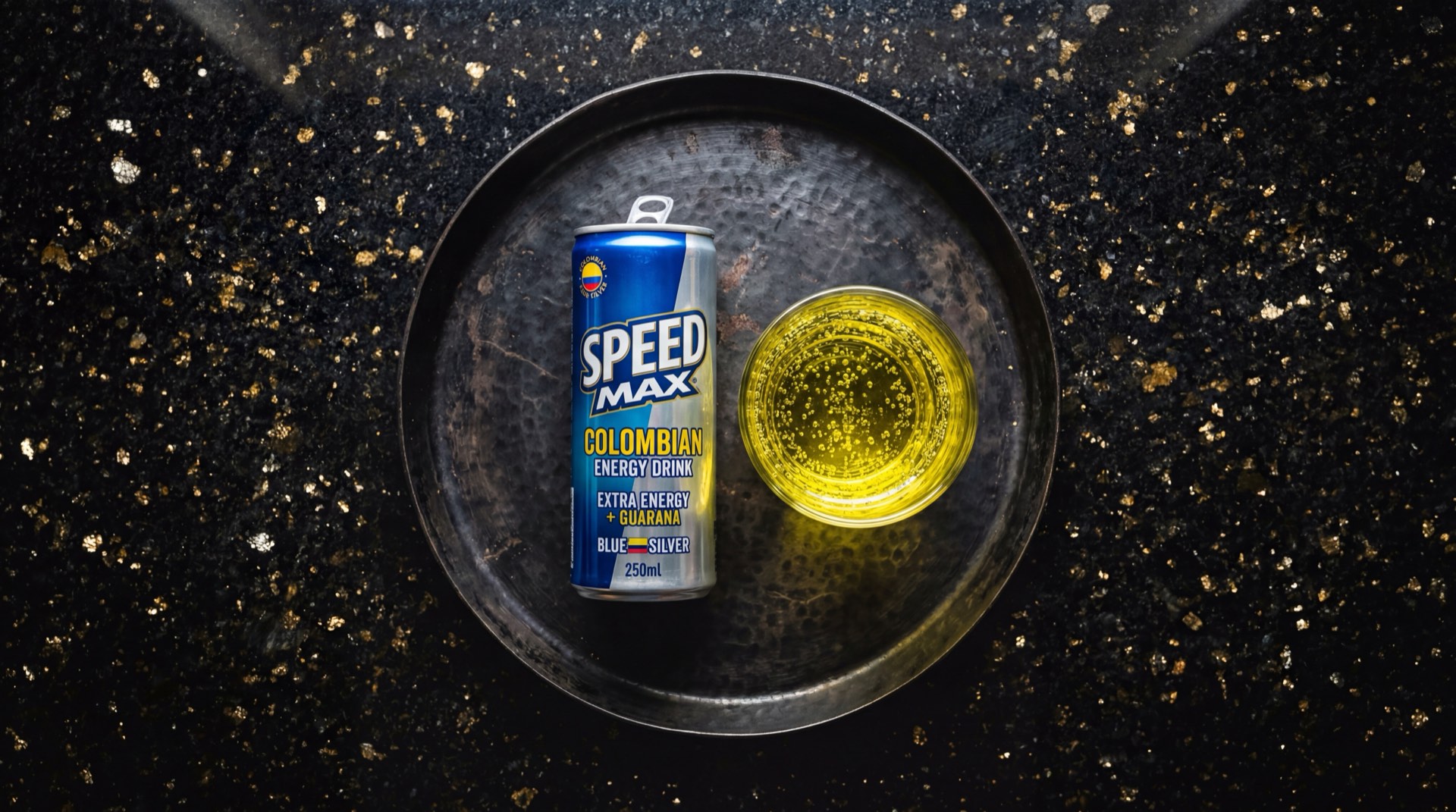 Speed Max de Postobon, lata azul y plateada de bebida energetica colombiana con cafeina y taurina sobre mesa de granito oscuro