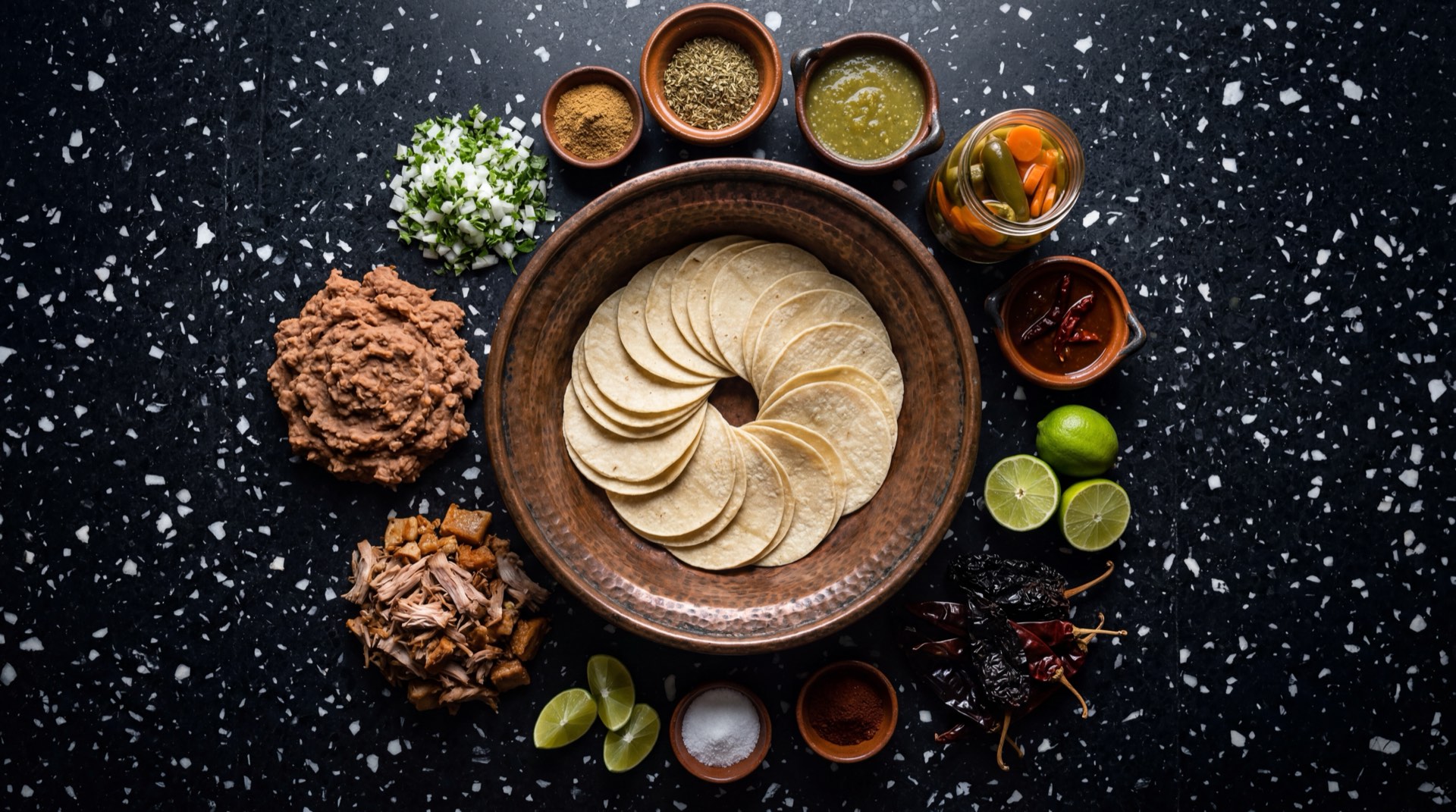 Ingredientes de los tacos de canasta mexicanos: tortillas de maiz nixtamalizado frescas, frijoles refritos de olla, chicharron prensado desmenuzado, papas medianas cocidas machacadas, chorizo rojo mexicano, salsa verde casera de tomatillo y aceite vegetal de canola
